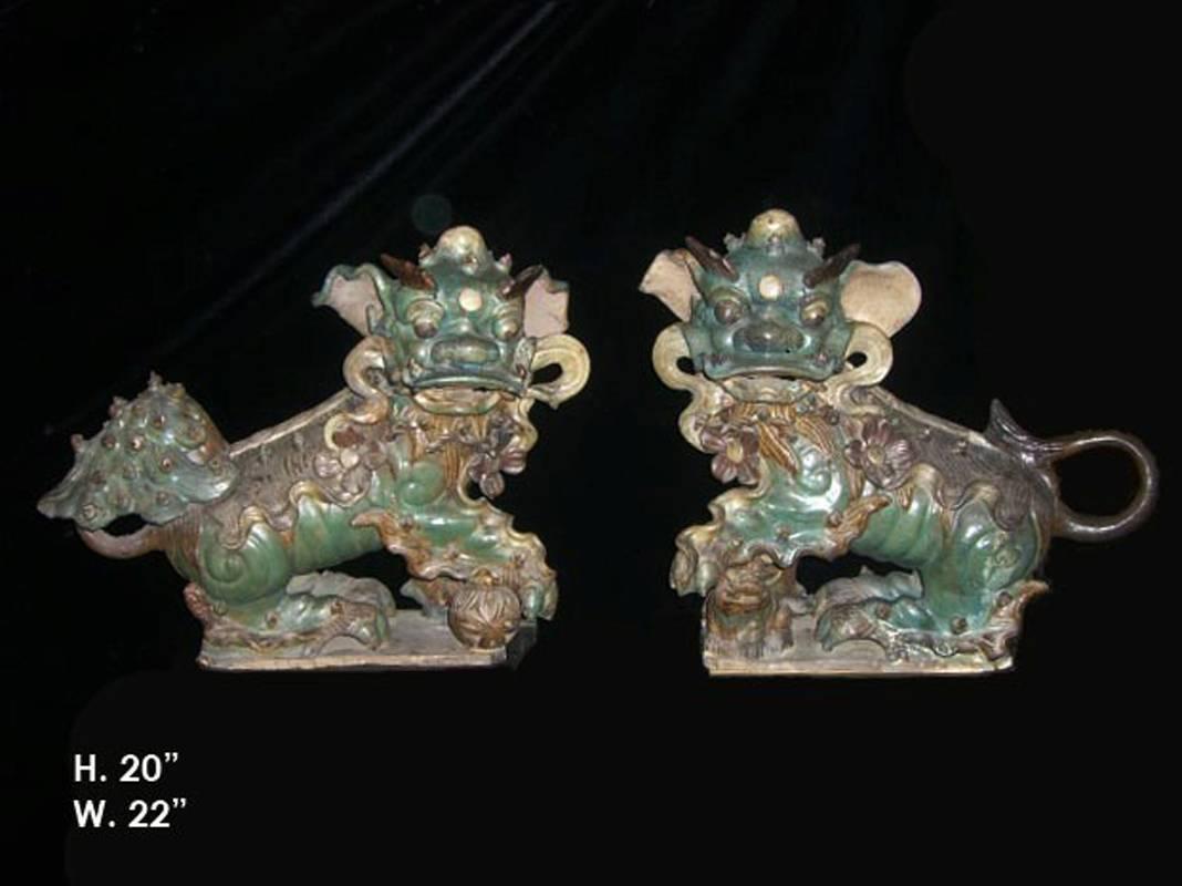 Outstanding late 19th century pair of Chinese green glazed ceramic whimsical foo dogs on later Lucite bases.

The dimensions for the Foo Dogs is: H. 20