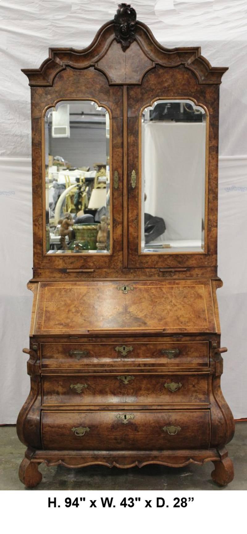 Fine 18th century Dutch Baroque burl walnut veneered secretary cabinet. The intricately carved crown centers the curved cornice tops two mirrored doors revealing shelving and two small drawers over two beautiful pullout candle stands. The slant