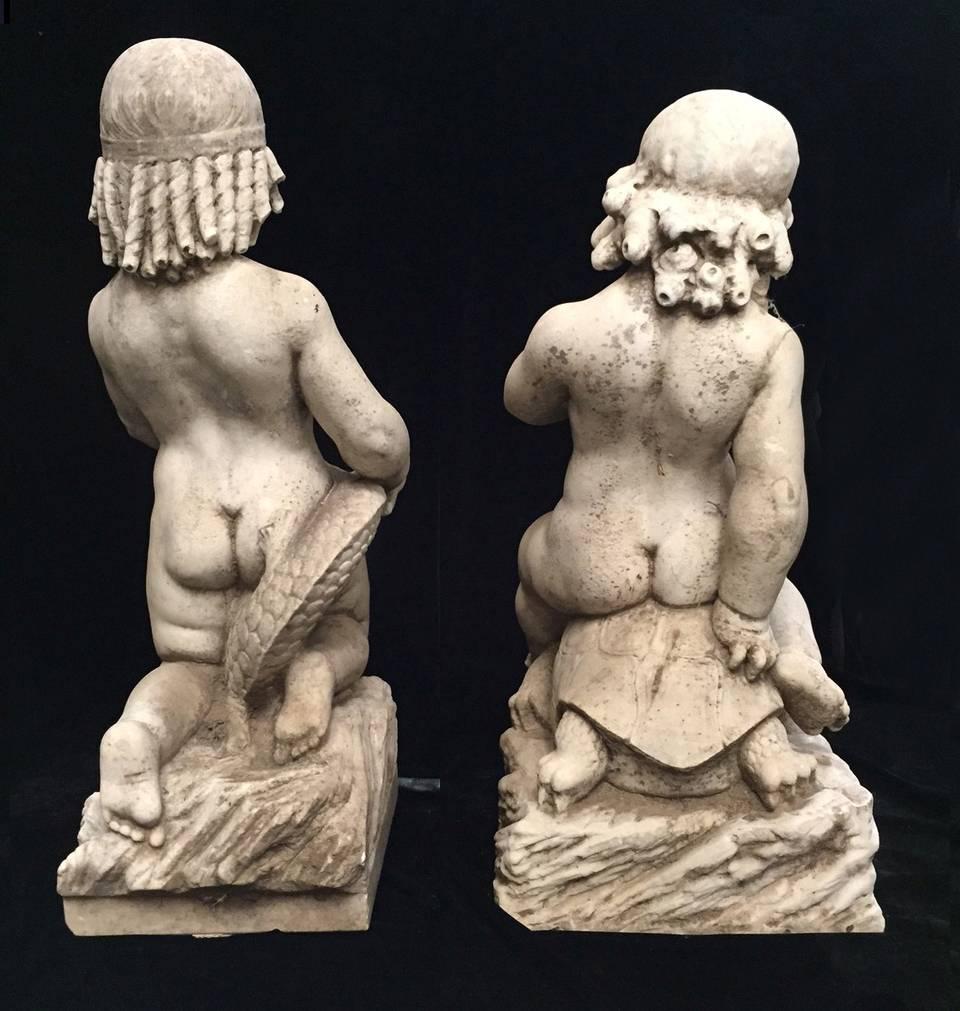 Exceptional pair of late 18th century Italian carved marble figural fountains. One holding onto a fish and the other boy holding a turtle with a leash. Both seated on rocky bases.

The measurements of the boy with fish (without pedestal) is: H. 26