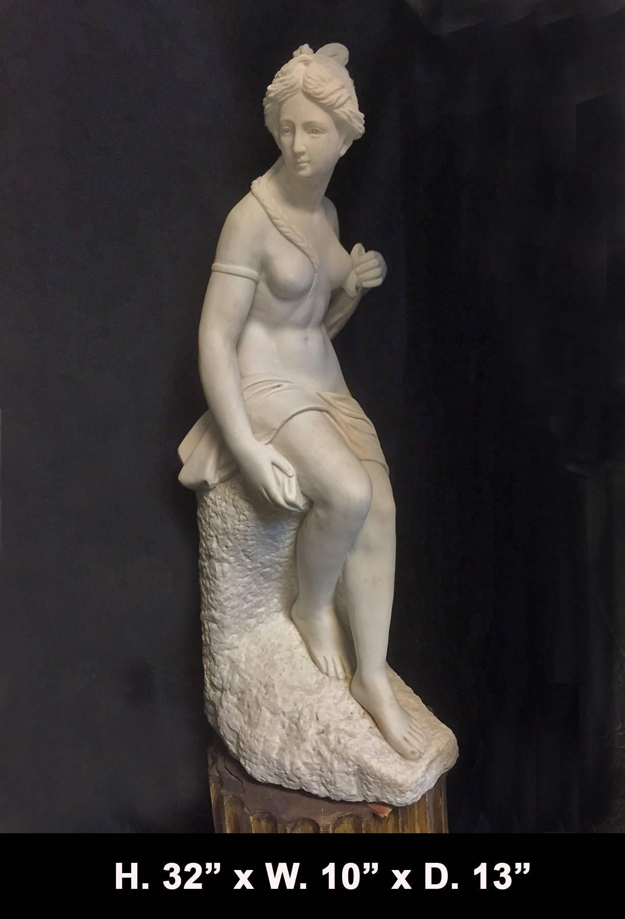 Attractive Italian neoclassical style hand-carved white marble statue of a woman seated on a rock with braided hair holding her draping garments over her shoulder.
  
         