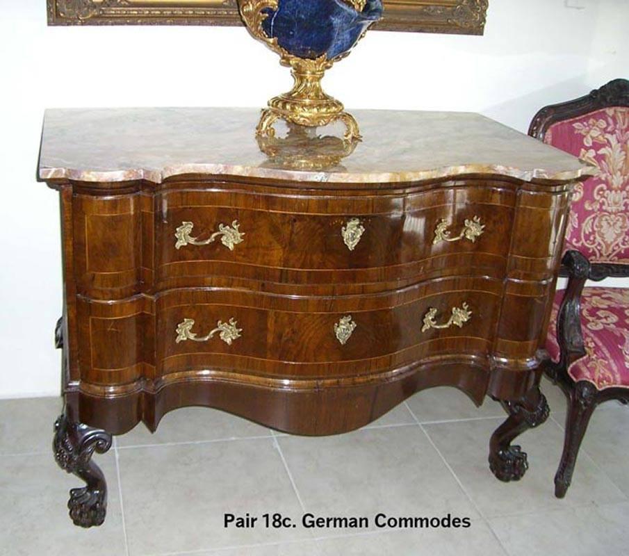 Remarkable pair of German serpentine-fronted commodes, the cases early 18th century, the legs and tops late 19th century.
The exotic marble tops above veneered two long serpentine drawers mounted with scrolling foliage bronze handles, all on