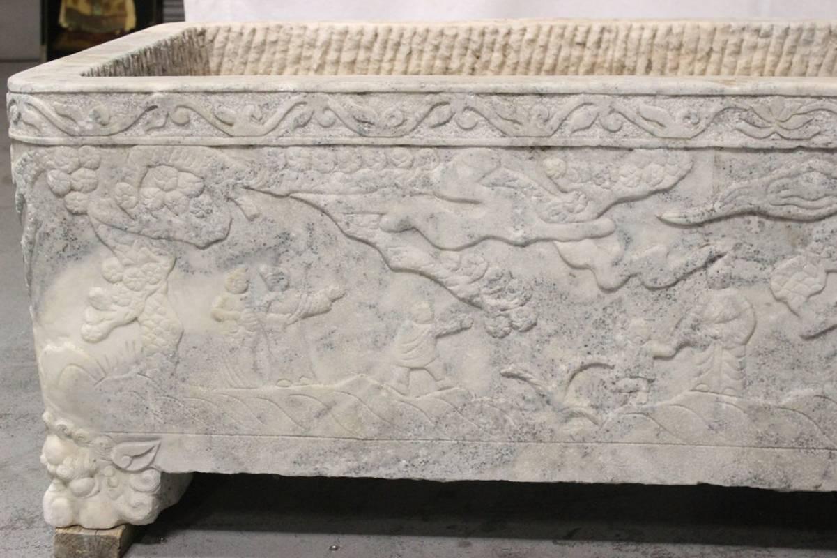 Large impressive 18th century or earlier, continental hand-carved marble planter with carved figural scenes on all four sides resting on four mystical animal feet.

