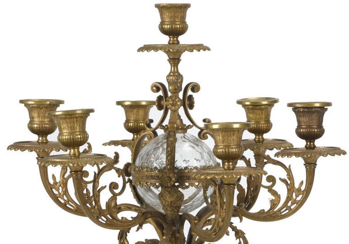 Extremely unusual pair of 19th century large French gilt bronze and cut crystal seven light candelabra each with seven scrolling foliate arms centered by a cut crystal ball above crystal ornament within ormolu foliage support sitting on leaf motif