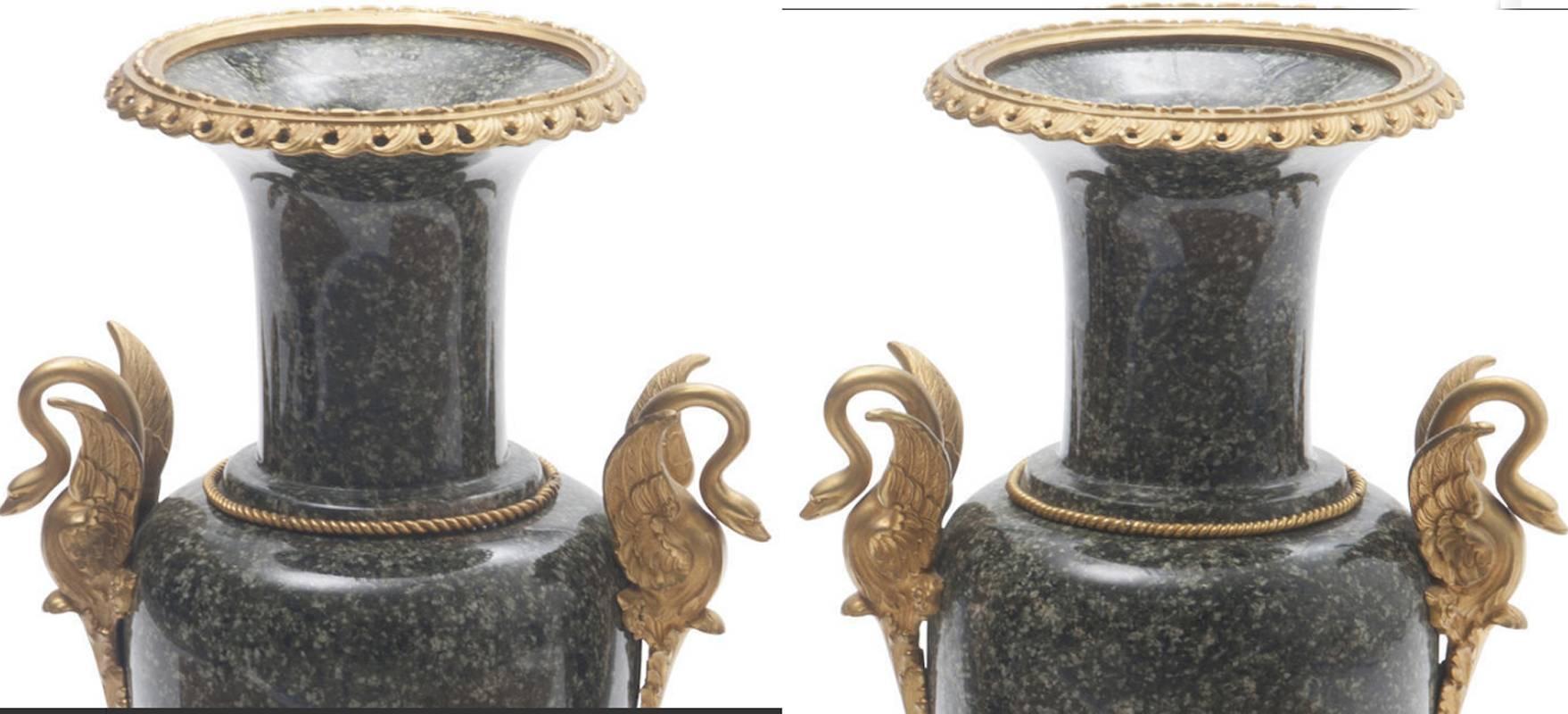 Attractive large pair of Louis XVI style gilt bronze-mounted marble urns. Each round ormolu rim over flared neck on ovoid form body flanked ormolu swan handles, all resting on marble square bases with gilt bronze bracket feet.

The measurement of