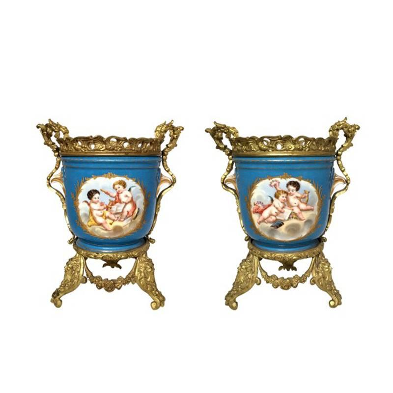 Attractive pair of 19th century French Sèvres style hand-painted porcelain ormolu-mounted planters.
The Sèvres style porcelain is hand-painted with cherub motif on one side and floral bouquet on other side, mounted with intricate gilt bronze.

   