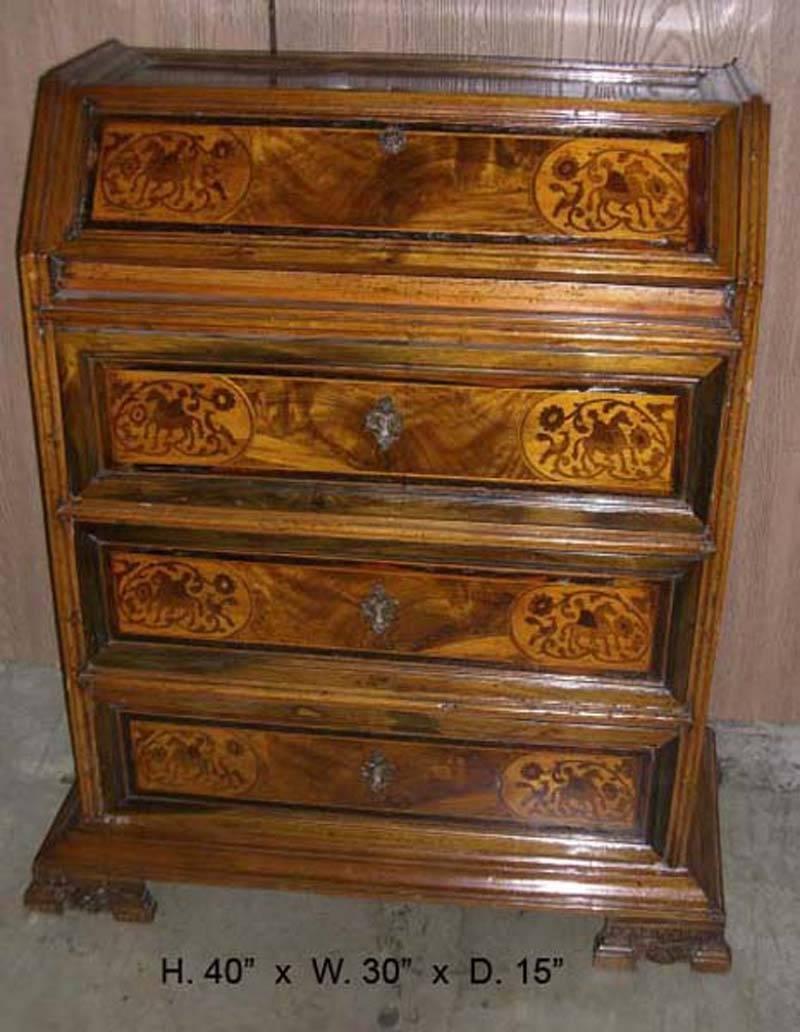 Italian Baroque inlaid slant front desk, 17th century. The slant front door reveals three small floral inlaid drawers over three drawers with inlay of horse and rider, on unique carved bracket feet with shell.