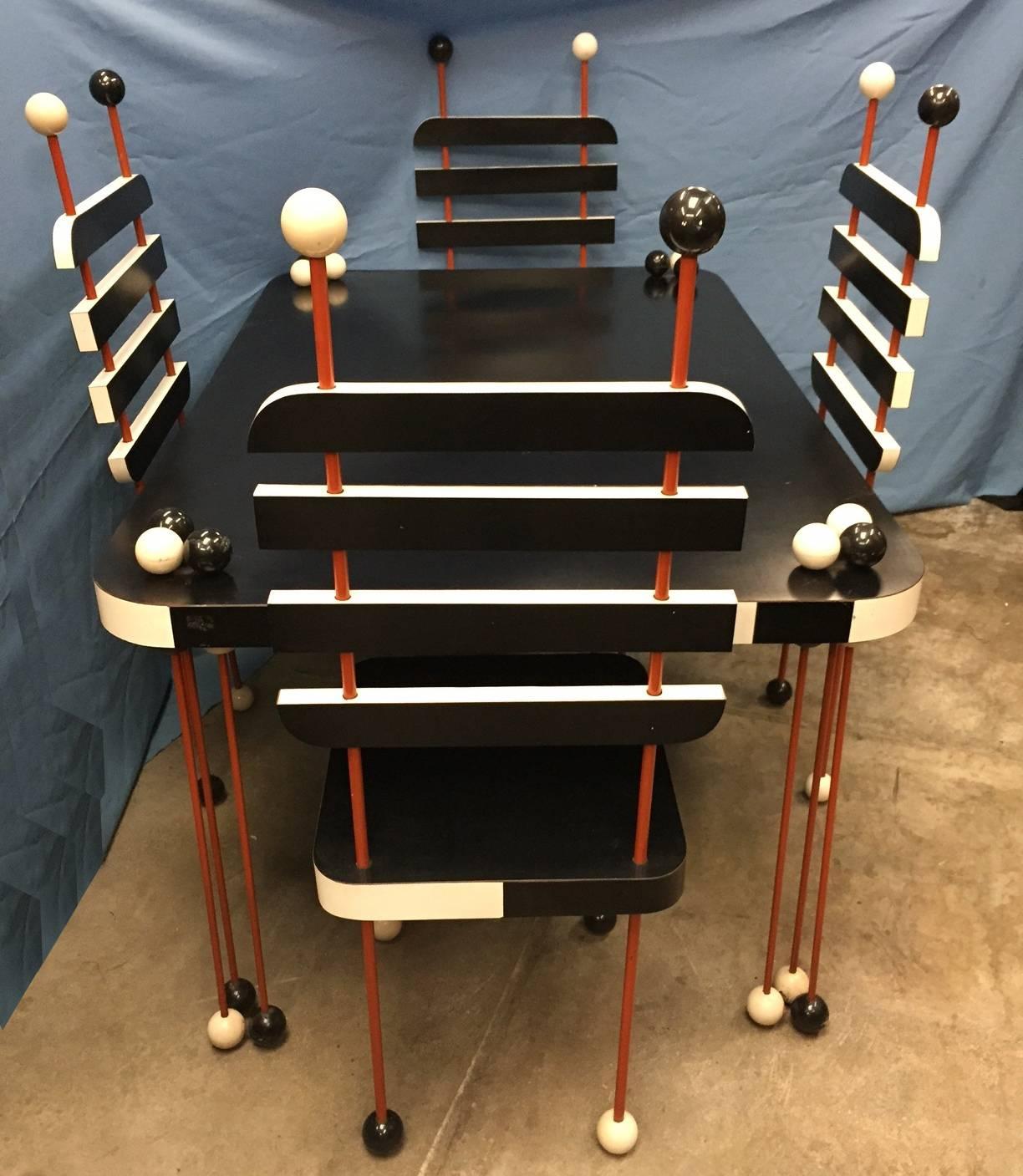 Unique Italian Post-War Modernist black and white five-piece dining set consisting of rectangular dining table and four side chairs, decorated with balls. Circa 1970s.

Measures: Table H 30 inches x W 55 inches x D 36 inches
Chairs H 44 inches x W