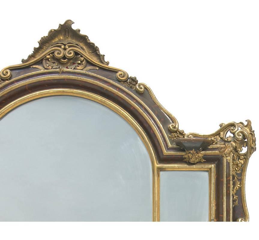 Exceptional large 19th century Italian faux tortoiseshell painted mirror. The frame of the mirror is decorated with parcel-gilt double scrolls, floral and foliage motif over hand-painted faux tortoiseshell and centered by large candleholder