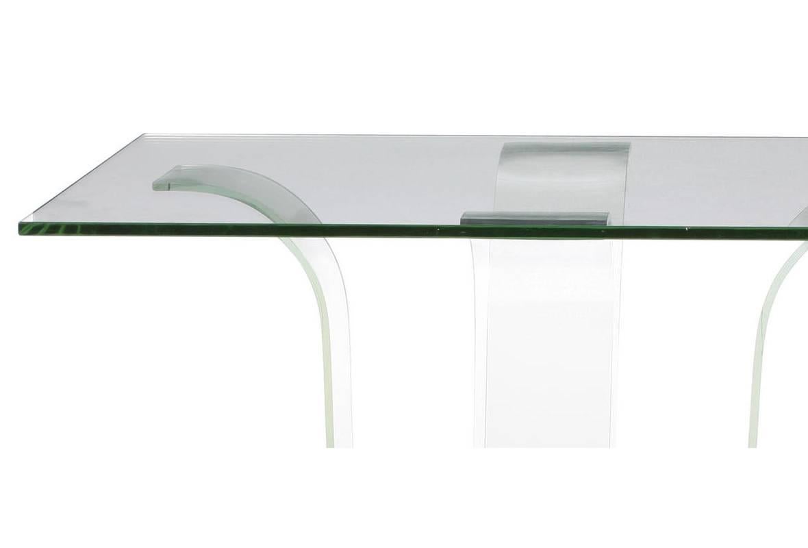 Table centrale contemporaine en verre et bois. Plateau en verre épais reposant sur quatre supports en verre incurvés sur une plinthe en bois. 

L'épaisseur du plateau en verre est de 3/4 de pouce.