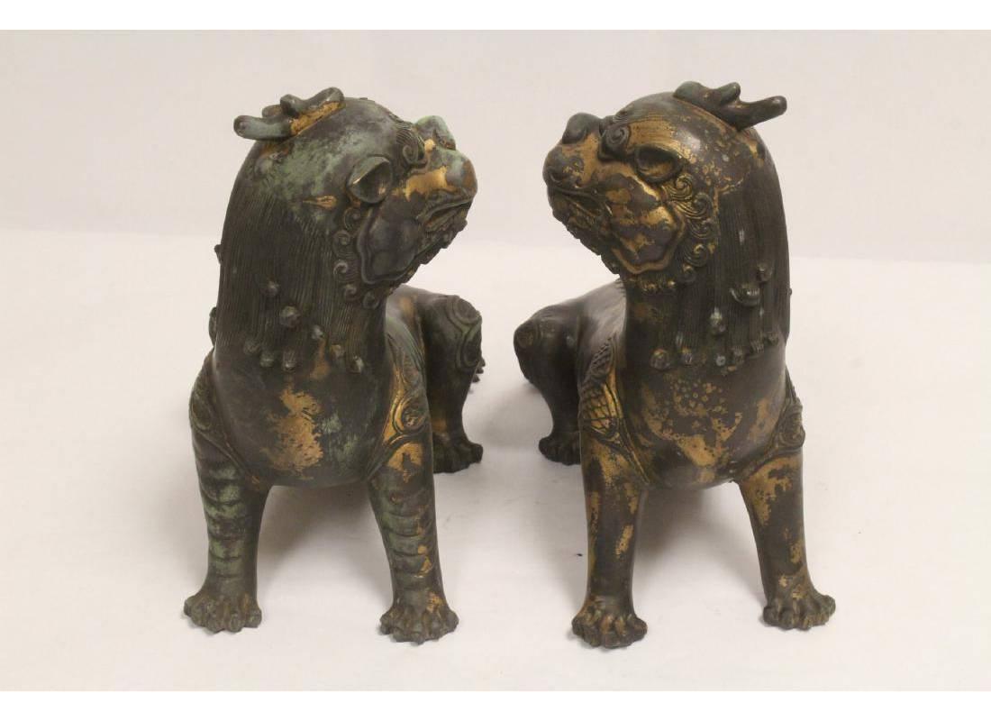 Decorative matching pair of Chinese patinated bronze seated fu lions. Mid-20th century.

 