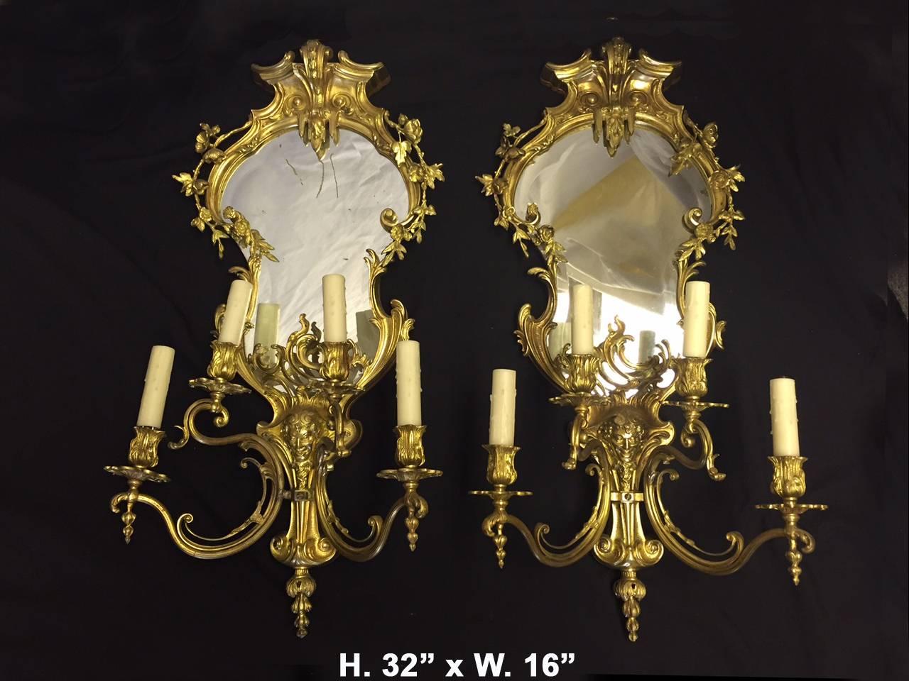 Attractive pair of French Louis XV style gilt bronze four light girandole mirrors with floral garland draped over beveled mirrors, circa 1900.

 