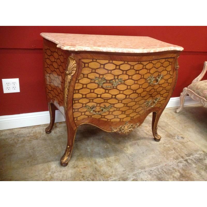 Impressive and unique late 19th-early 20th century Italian Rococo style inlaid bombe commode. 
Beige serpentine-fronted marble top over two drawers inlaid in tortoise shell motif and mounted with acanthus bronze handles. Corners are carved giltwood