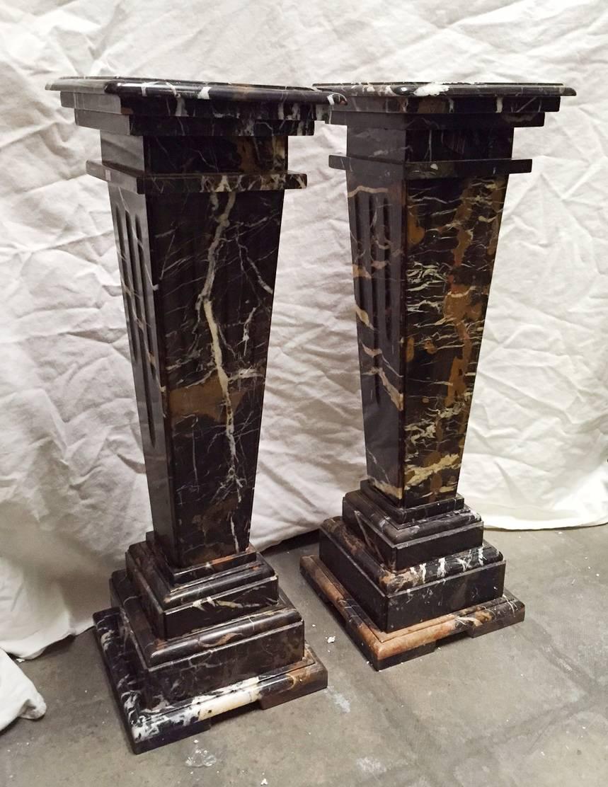 Pair of neoclassical style fluted gold and black marble pedestals. With square tops. 

Additional colors available:
- White
- Beige.
 