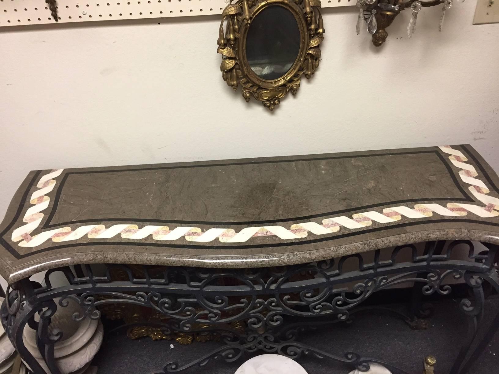 Fine Italian Baroque style hand-forged wrought iron and bronze console with inlaid marble veneered top. Beautifully veneered marble top over wrought iron frieze with scroll motif flanked by bronze lion masks with ring, all on scrolled legs