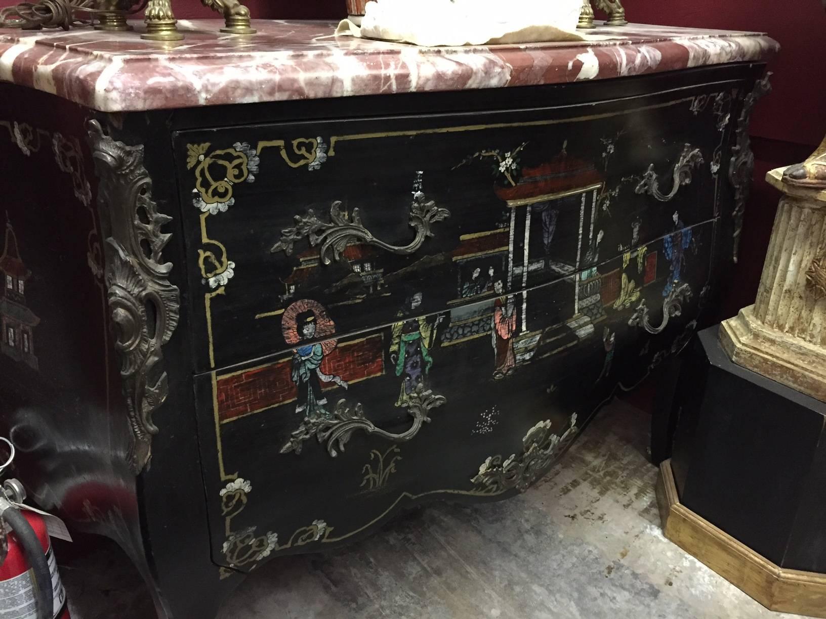 Pair of Louis XV style chinoiserie marble-topped commodes.
The unusually think marble tops over ebonized bombe commodes hand-decorated with chinoiserie motif and bronze-mounted with intricate foliage work, all resting on four cabriole legs ending