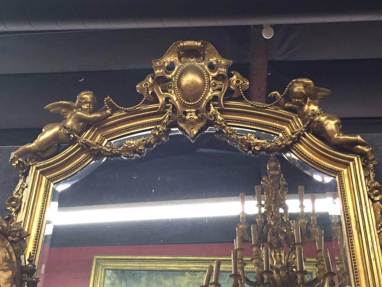 Imposing 19th century Italian gilded pier mirror with putti.
The top is centred by a gilt medallion flanked by a pair of beautiful putti with foliage swags, all-over fluted sides and further foliate motif.