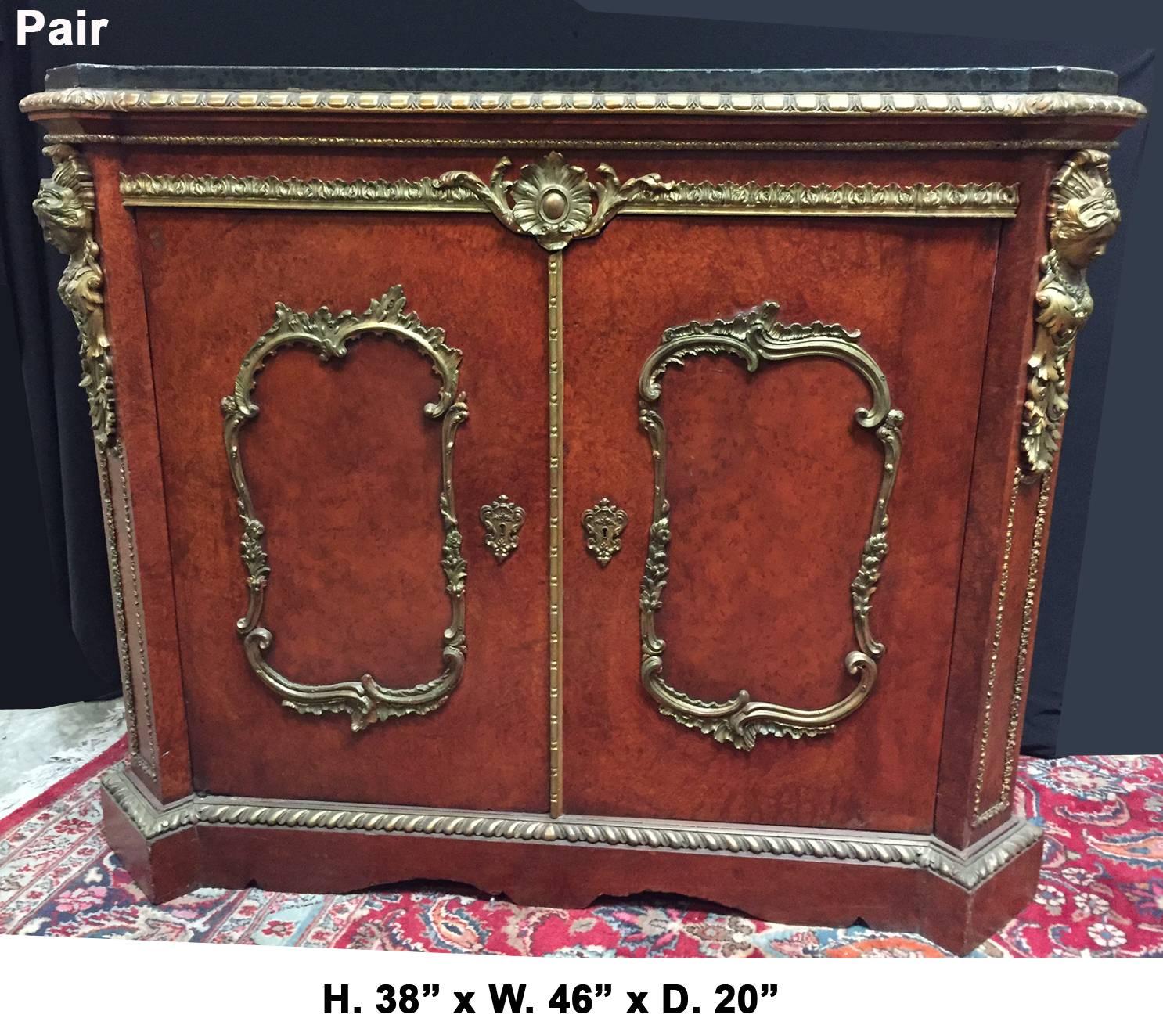 Outstanding pair of 19th century French gilt bronze mounted two-door meuble d'appui cabinets.
The greyish black marble tops over two gilt bronze-mounted doors, revealing a shelf, flanked with ormolu figures and centred with foliage motif