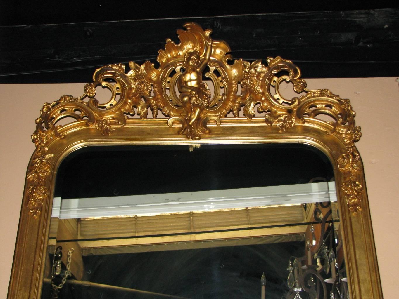 Extraordinary 19th century French Louis XV style gilt mirror with Sèvres Porcelain plaques. 
The mirror is topped by rocaille ornament centered by beautiful seated putti holding a wreath. The sides are decorated with two hand-painted porcelain