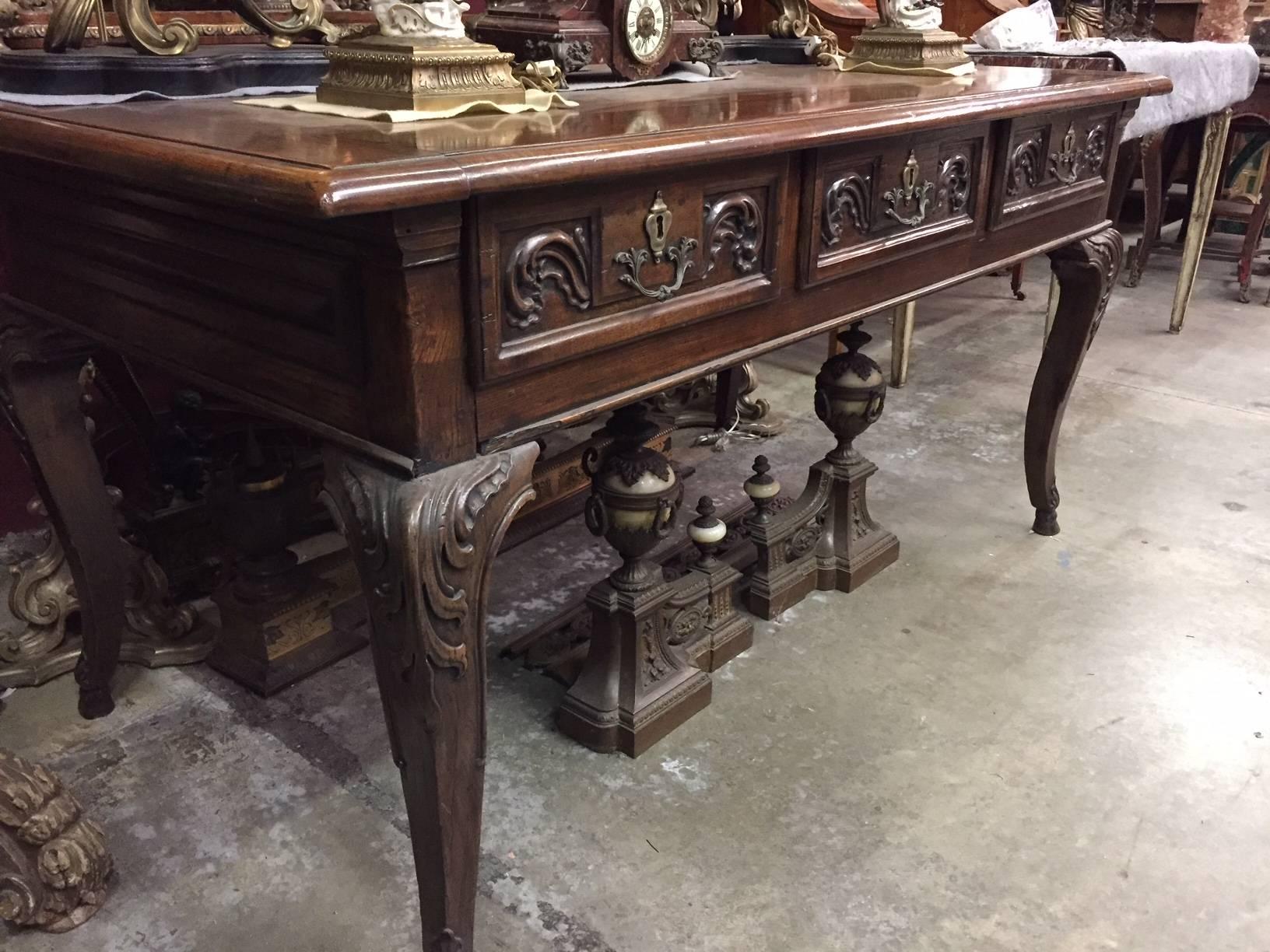 Fabulous 18th century Italian Baroque carved walnut partner's desk. 
The beautiful walnut rectangular top over a frieze containing six drawers, three on each side, all finely carved with foliage motif centered by bronze handles, resting on four