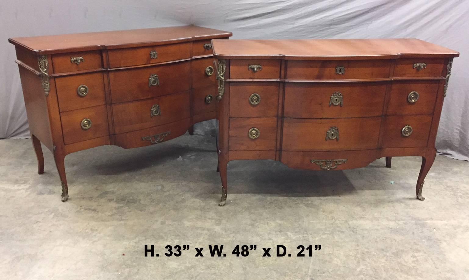 Impressive pair of French Louis XV / Louis XVI Transitional style bronze mounted fruitwood commodes with three small drawers and two large drawers all mounted with bronze handles, all supported by four cabriole legs terminating in bronze sabots.