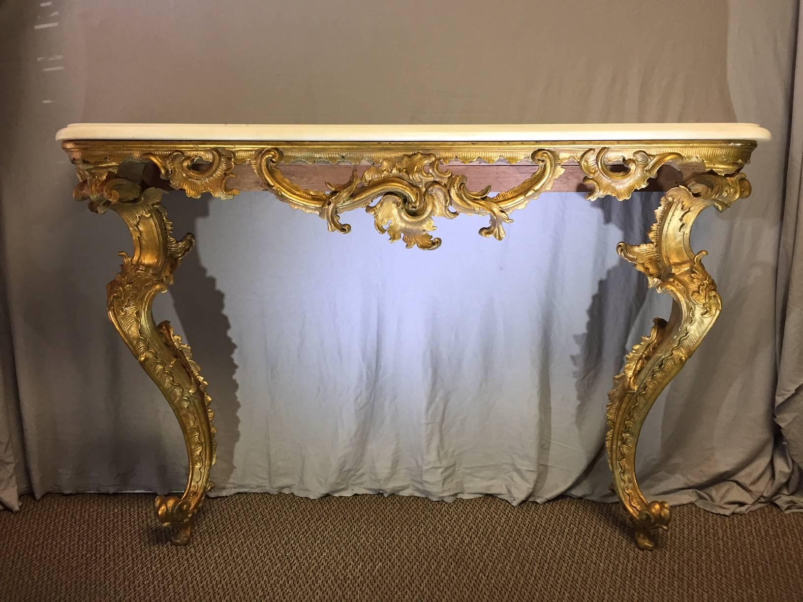 Imposing 18th century Italian Rococo giltwood console. Solid white marble top over hand-carved giltwood console with Rocaille shell and foliage motif, resting on two beautiful carved giltwood scrolled legs.