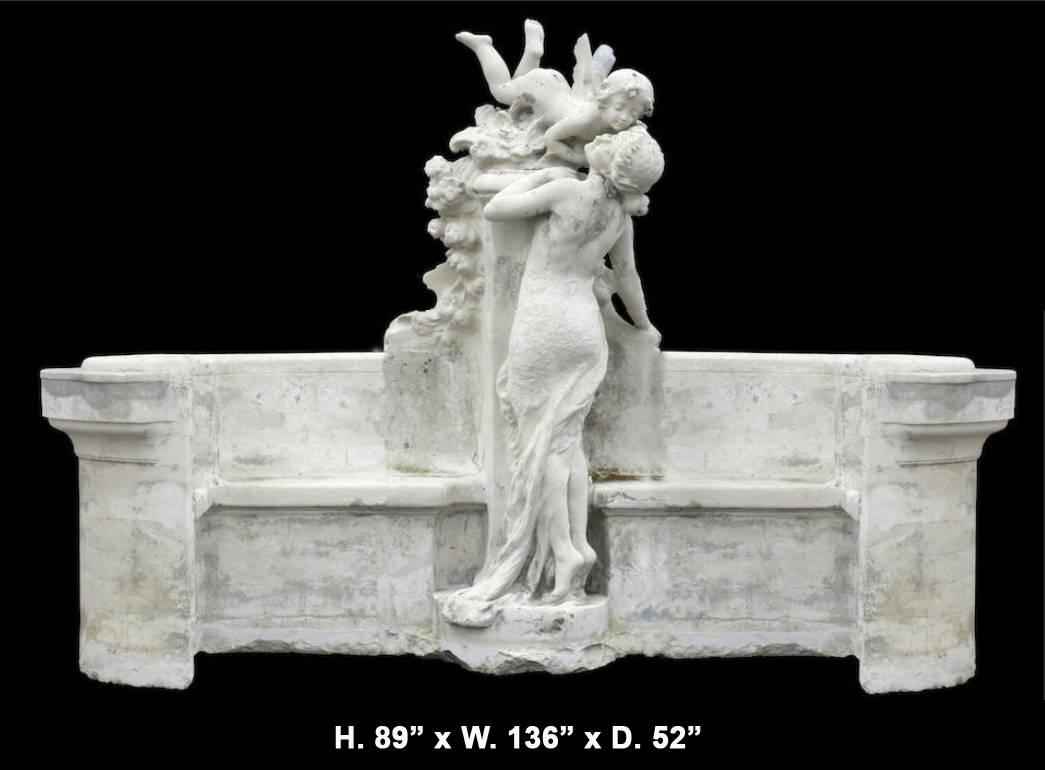 An important and monumental 19th century French figural garden cast stone bench centered by a flying cherub over floral bouquets and kissing a young maiden in a long beautiful dress.
The bench also features concave sides on the outer rim of the