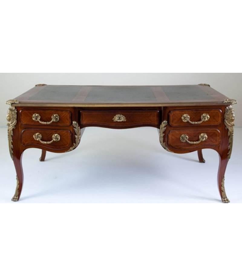 Impressive large 19th century fine French Louis XV style kingwood ormolu-mounted bureau plat. Bureau plat top with ormolu-mounted border has three green leather sections over five-drawers with bronze foliage motif, flanked by two large ormolu masks