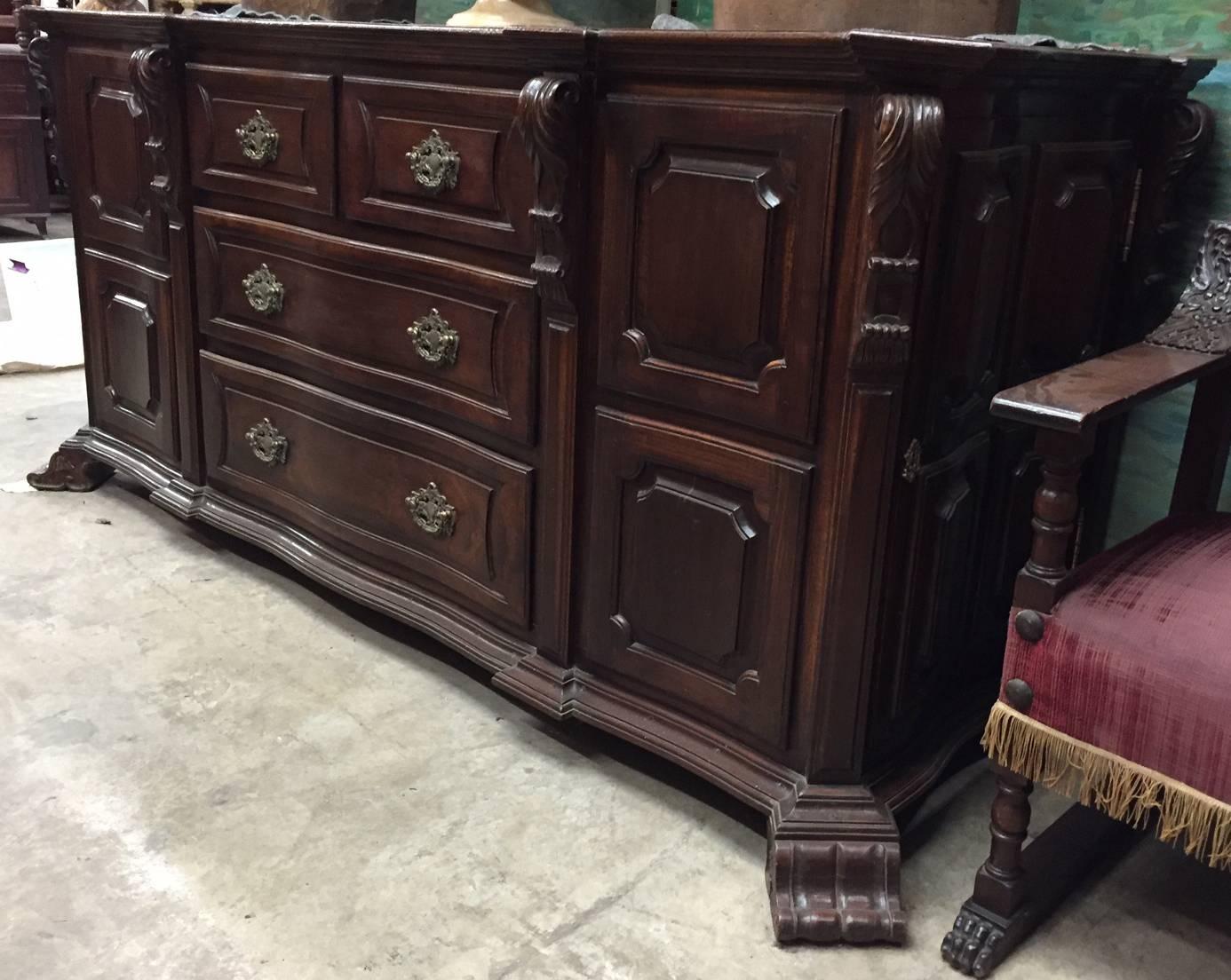 Important large late 18th-Early 19th century Brazilian Baroque style jacaranda rosewood credenza. The beautiful solid Jacaranda top over four drawers with intricate and large bronze handles flanked by two side cabinets with side doors, resting on