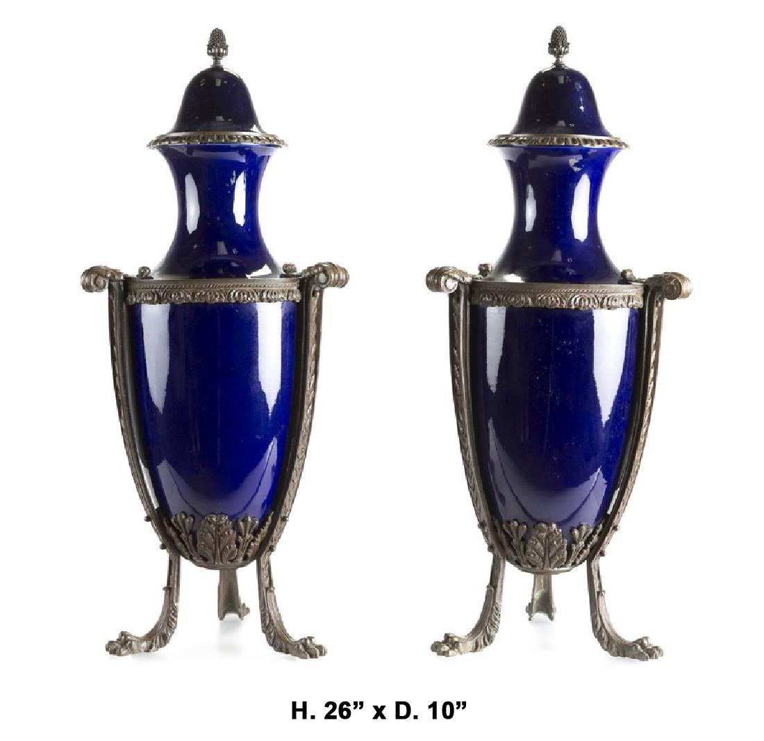 Pair of 19th century French neoclassical style bronze-mounted cobalt blue porcelain urns on tripod bronze base with lion feet.