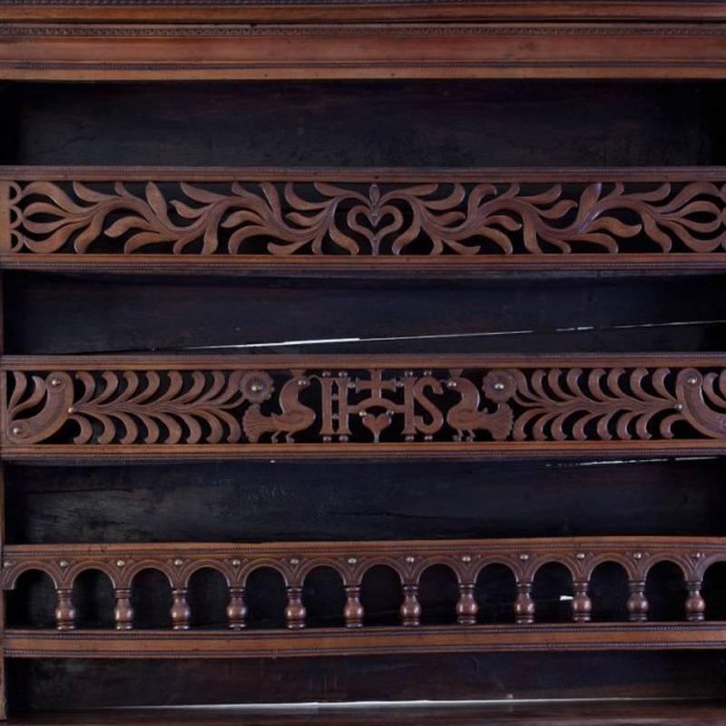 Finely carved French Louis XVI Provincial walnut Vaisselier, late 18th century. The top is with three fretwork patterned shelving, the bottom has extremely finely detailed carving with two drawers and two doors mounted with long brass mounts, all