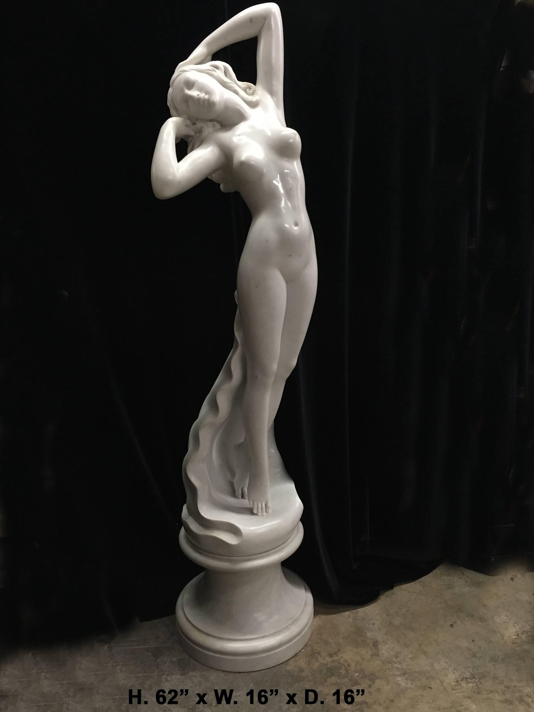 A magnificent and beautiful Italian finely carved white marble statue of a nude maiden rising out of the ocean waves, first half of the 20th century. Her arms elegantly playing with her long hair and a beautiful expression on her face. This statue