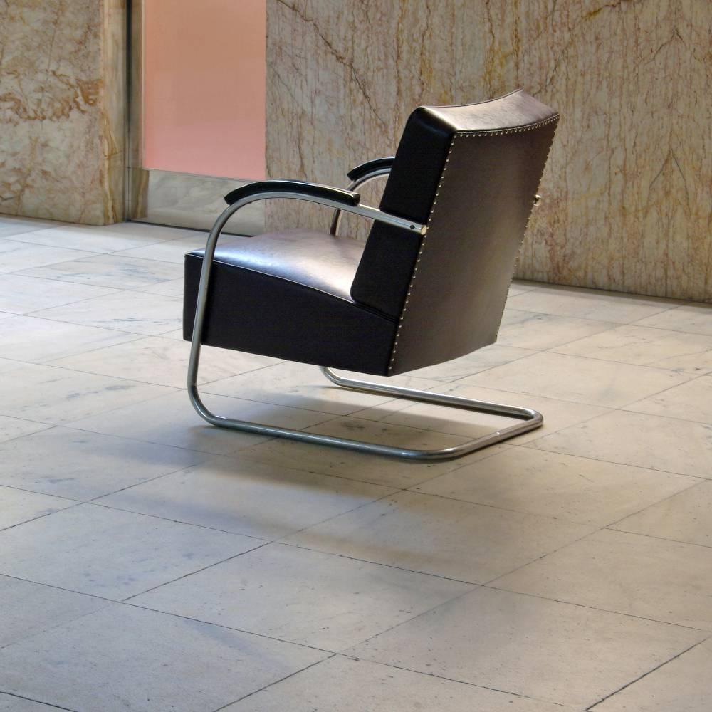A low tubular steel cantilever armchair made of chrome-plated tubular steel in a single open continuous line. This elegant original 