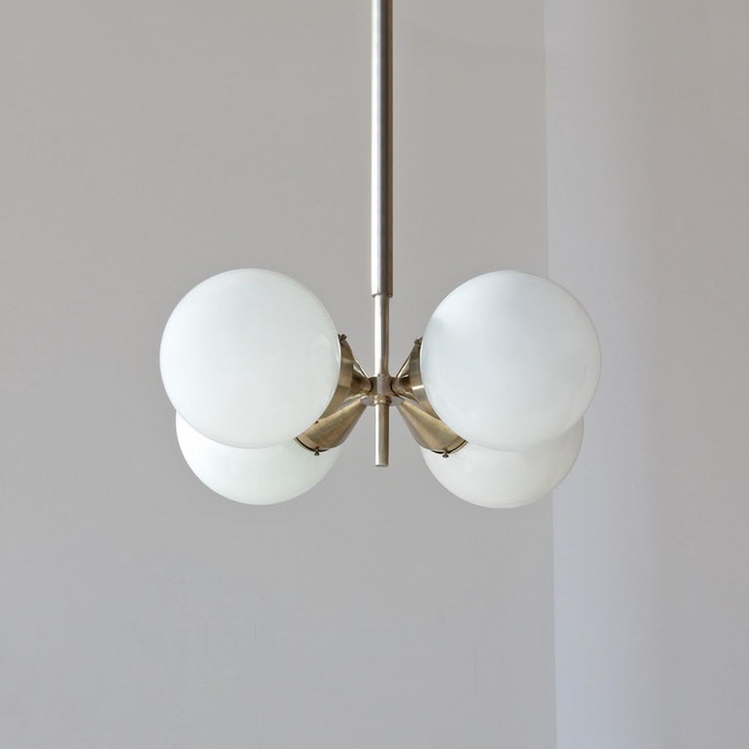 Lampada a sospensione modernista con 4 lampadine in vetro opalino, ottone nichelato, personalizzabile.
Tempo di produzione: 8-9 settimane.