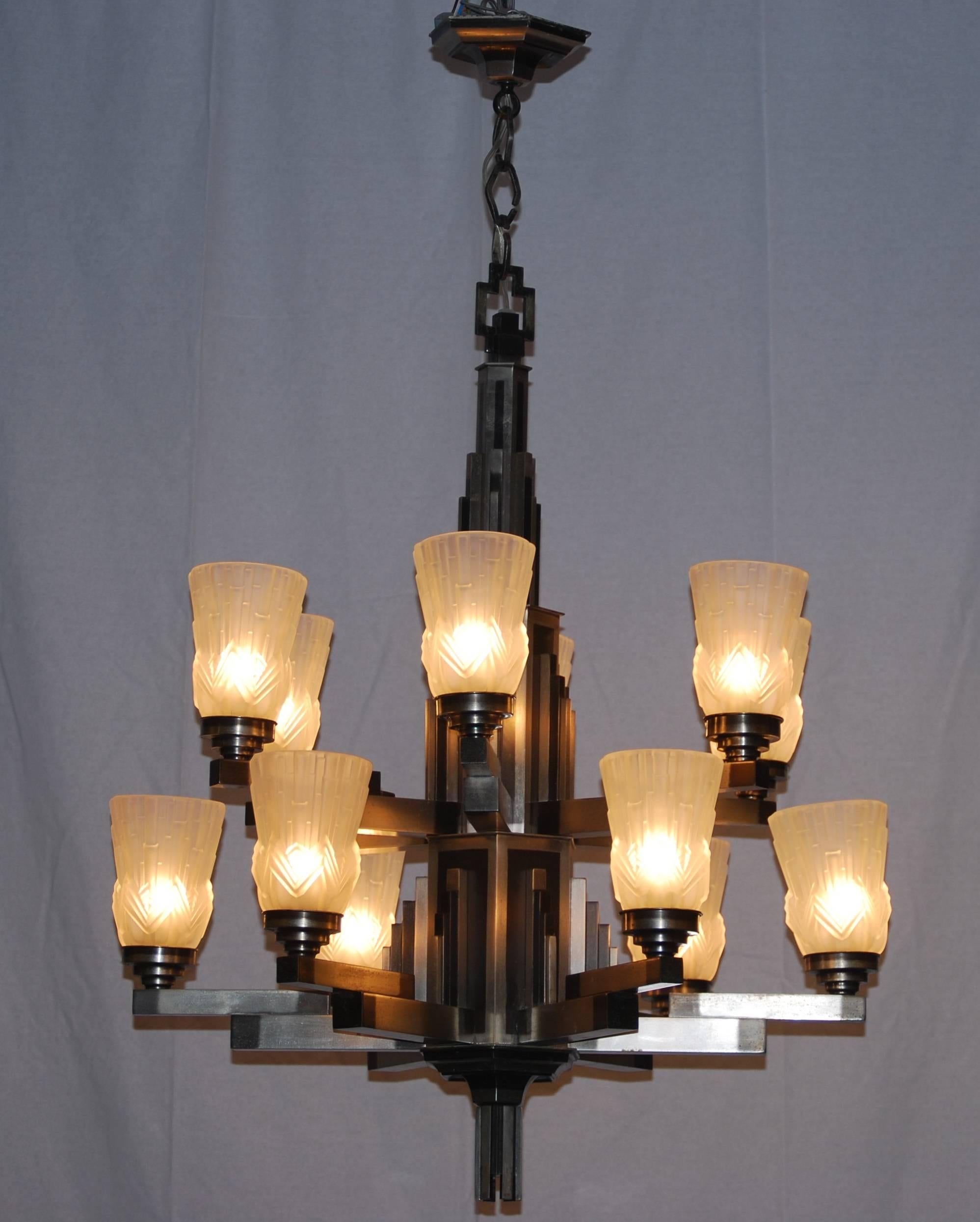 One-of-a-kind!.
This cubist 12 lights nickel with black details chandelier is recently restored.
12 frosted glass chades are mounted on the arms.
This chandelier is made in France in the Art Deco period 1920-1930.
     
       