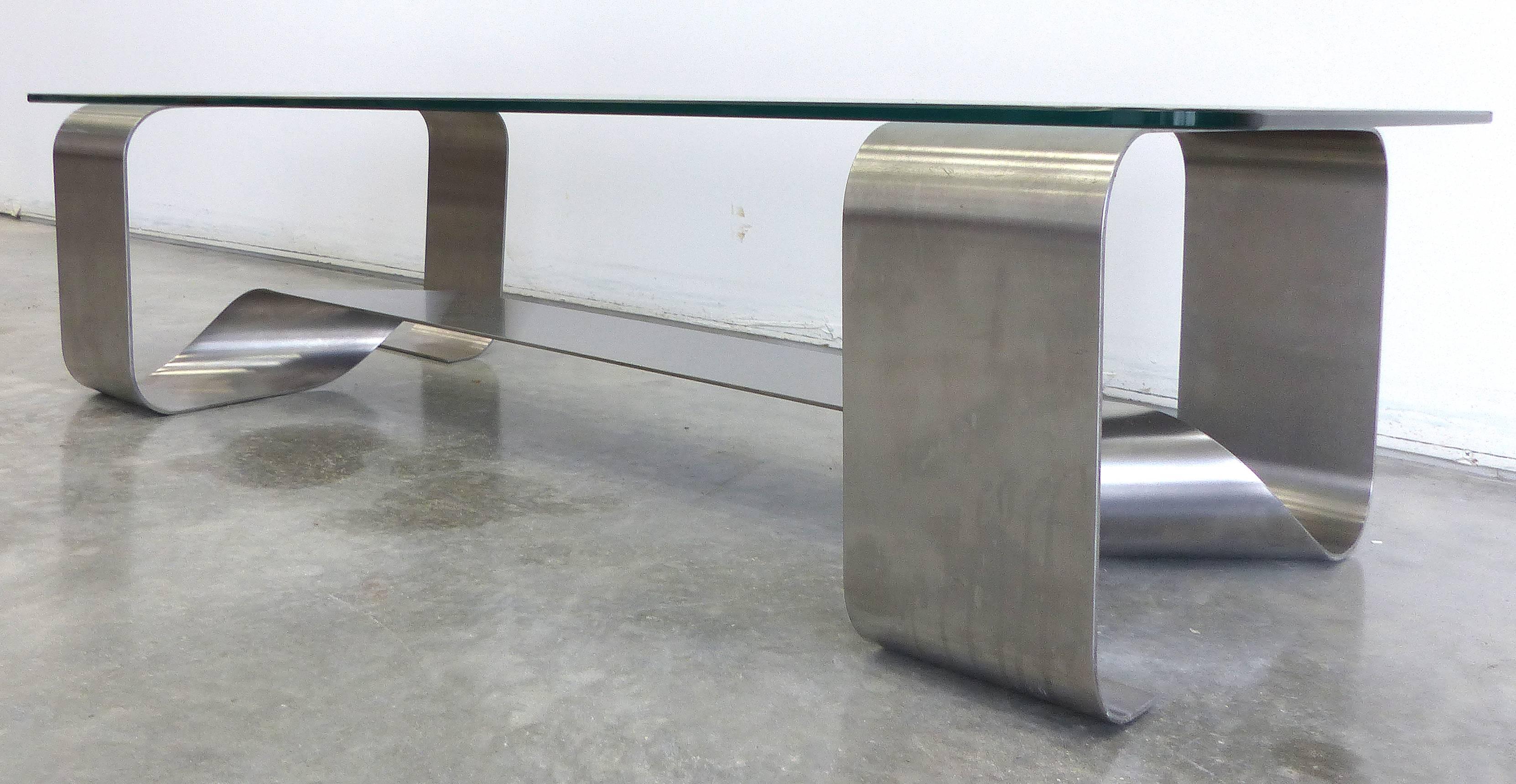 A sculptural low Mid-Century Modern stainless steel ribbon coffee table attributed to Michel Boyer Glass top with rounded corners. Visually quite interesting from any angle. Minor finish wear to the metal commensurate with age.

 
 
 