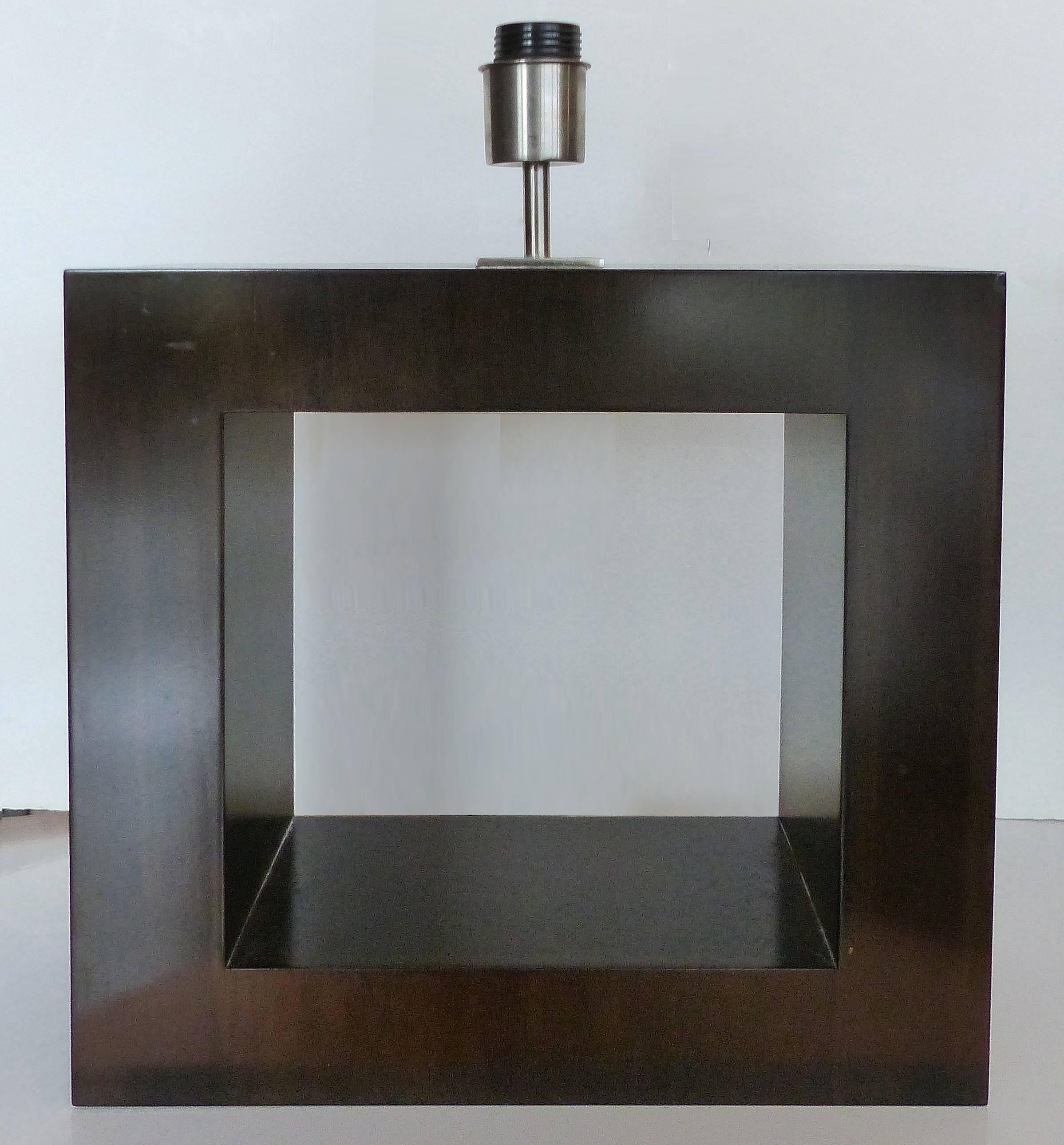 Mid-Century Ebonized Wood Table Lamp

Offered is a Mid-Century Modern open center square wood table lamp that has been ebonized to a deep brown-black finish. The fittings are aluminum and the custom shade is laminated cloth with fabric edging.