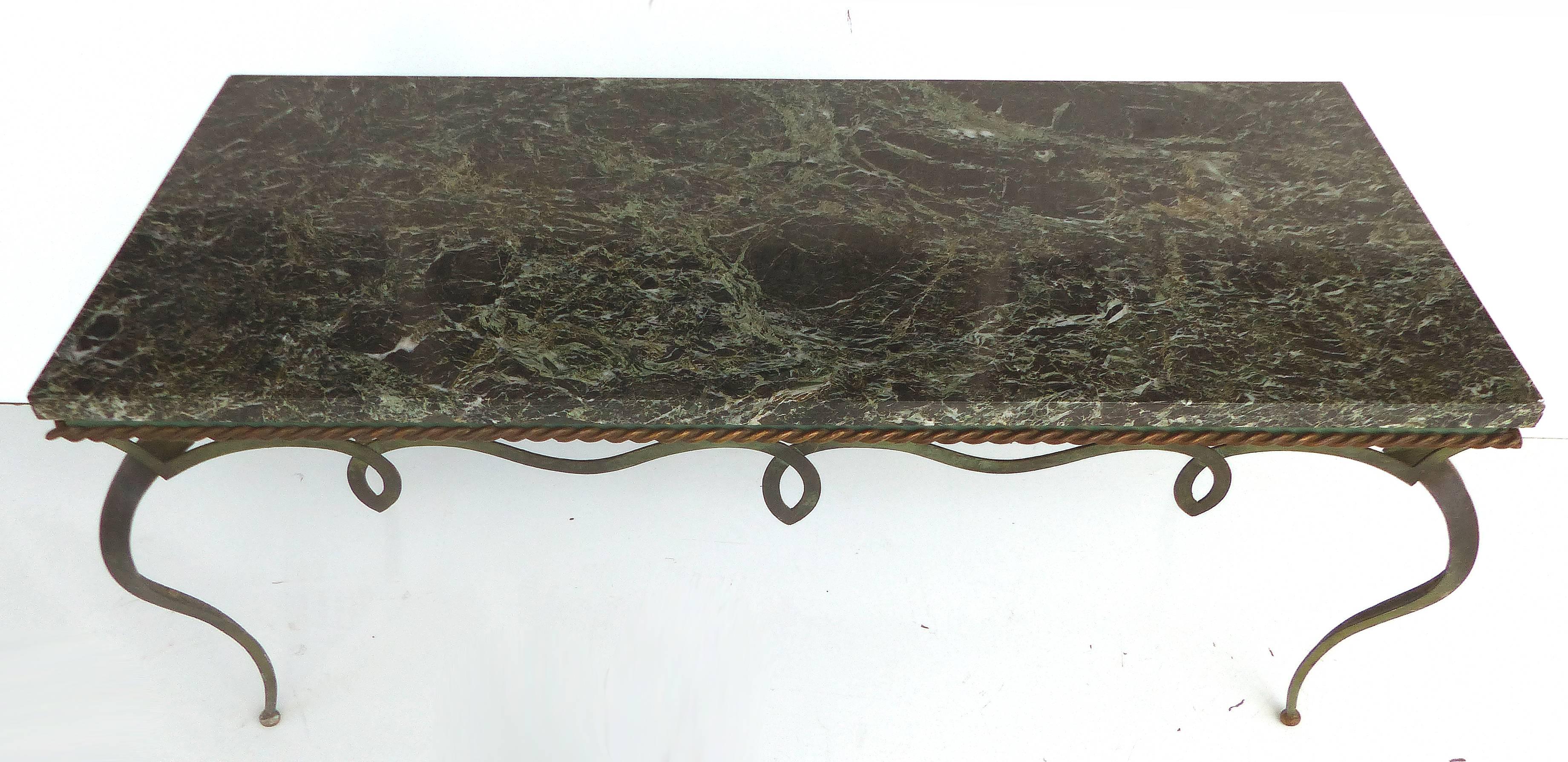 A forged iron coffee table in the style of Gilbert Poillerat with a dark green patina, gilt accents and green and black marble top, The table's flowing stylized legs have a French flair. The marble is 1": thick.

 