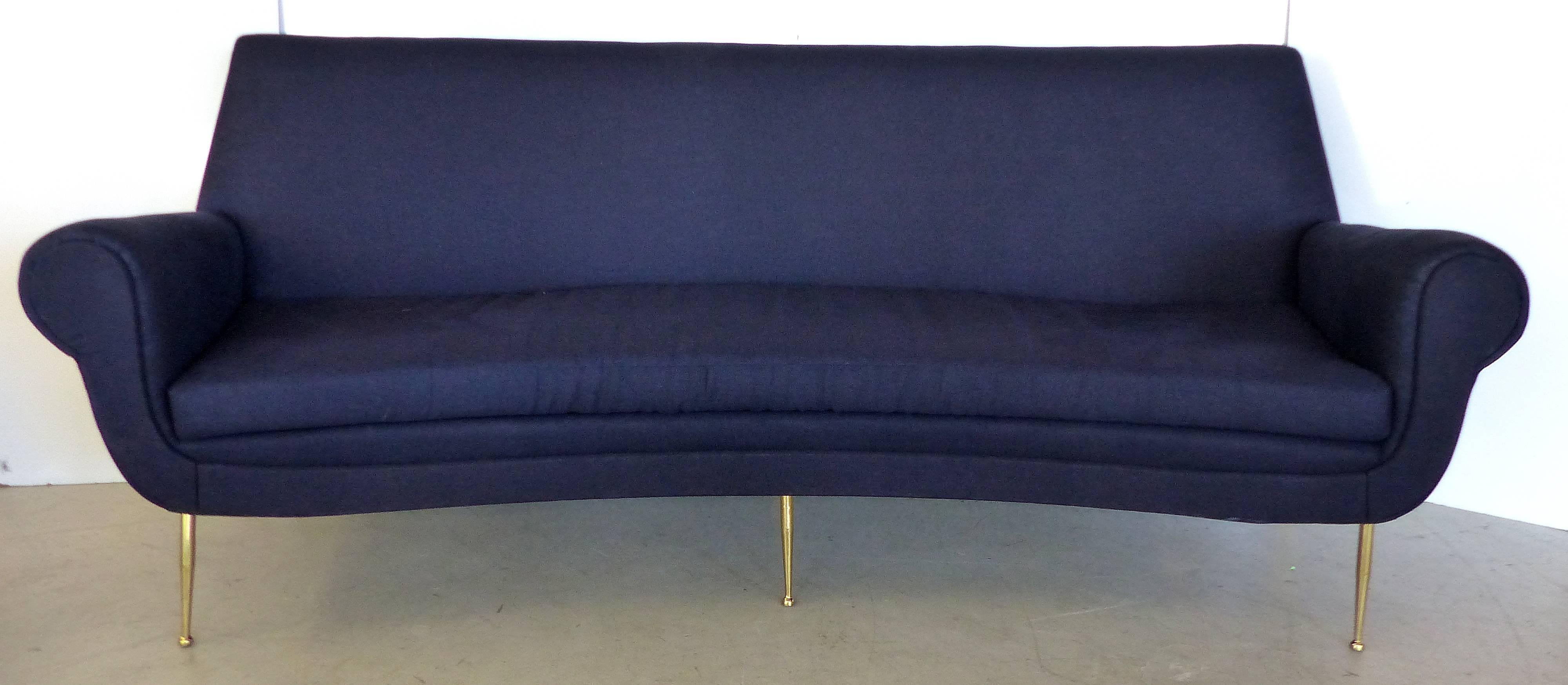 An elegant over-scale Mid-Century Modern Italian curved sofa by Gigi Radice with six polished tapered brass legs. The sofa has been fully restored and upholstered in a dark navy linen.