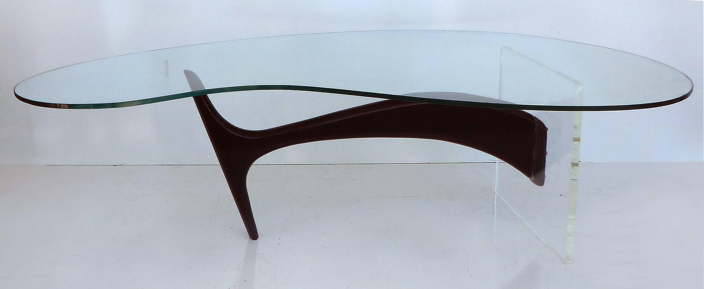 A sculptural lacquered wood and Lucite coffee table created in the manner of the Vladimir Kagan Omnibus Collection. The floating base supports a biomorphic shaped glass top. The glass shows surface wear commensurate with and including two minor edge