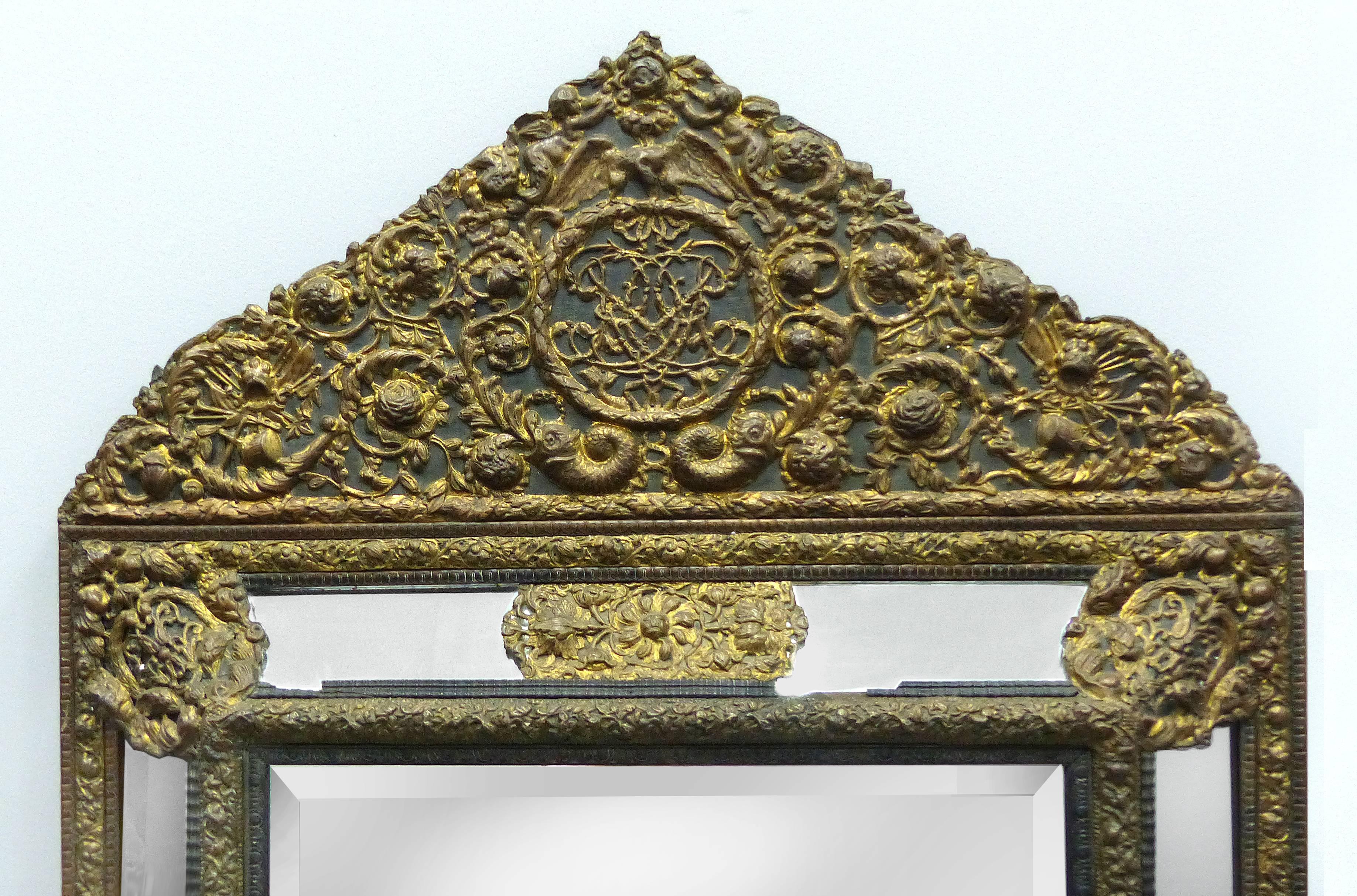 Offered is an 18th century Dutch Colonial bronze repose mirror with an ornate cornice and elaborate detailed panels. The main beveled mirror is a more modern.