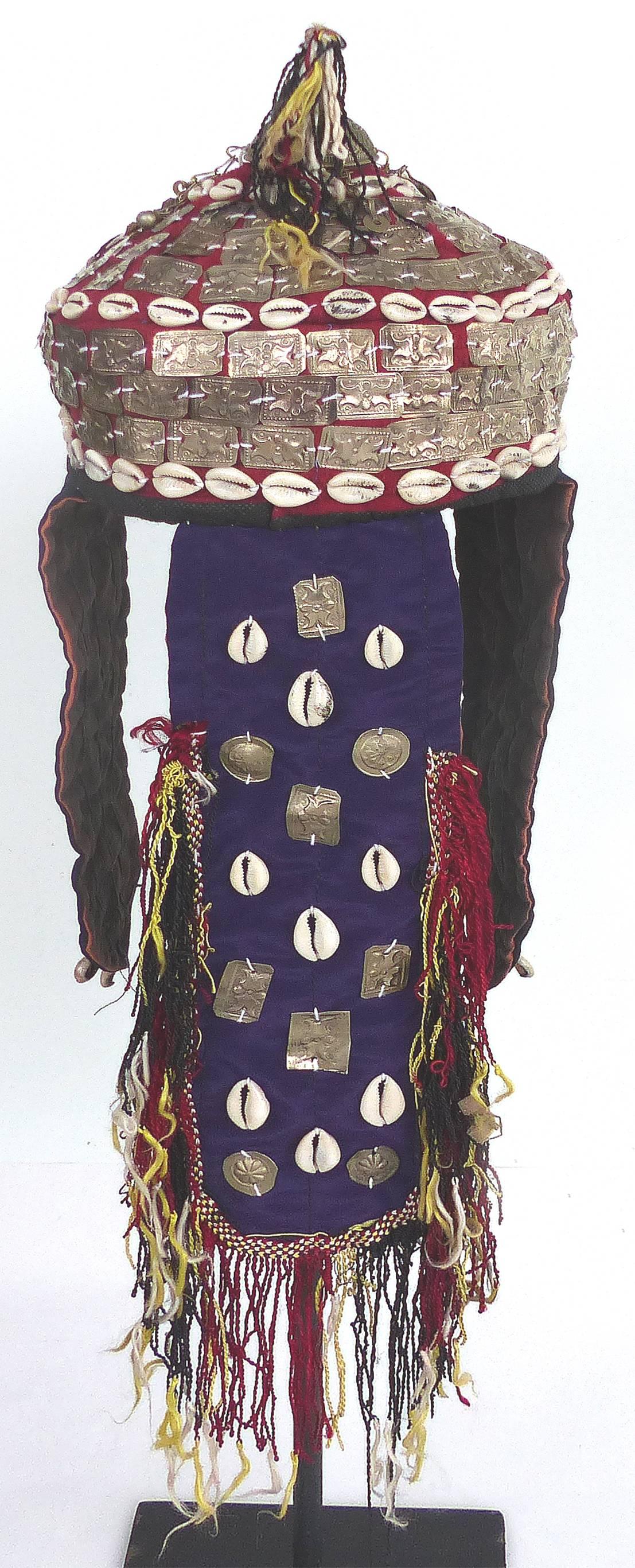 Offered for sale is a 20th century Turkmenistan wedding headdress presented on a contemporary metal stand. The headdress is handmade with fabric, shells and embossed and engraved metal in the ancient style of the Turkmenistan people.  Height when