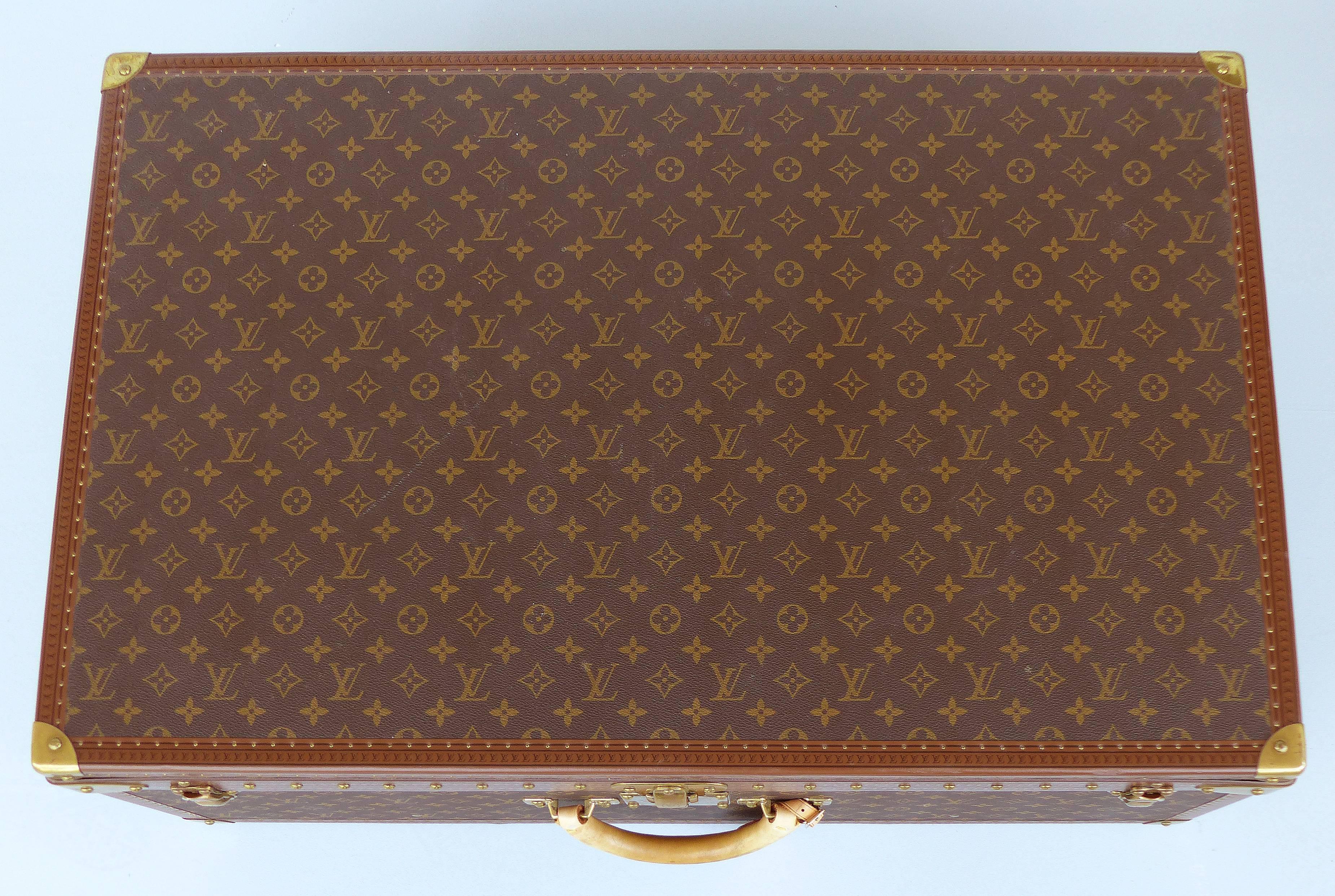 Offered for sale is a Louis Vuitton hard-sided leather Alzer 80 suitcase. The largest of this model, this beautifully crafted suitcase has the monogram finish, brass hardware, it's original protective outer cover and it's serial number 1067519. In