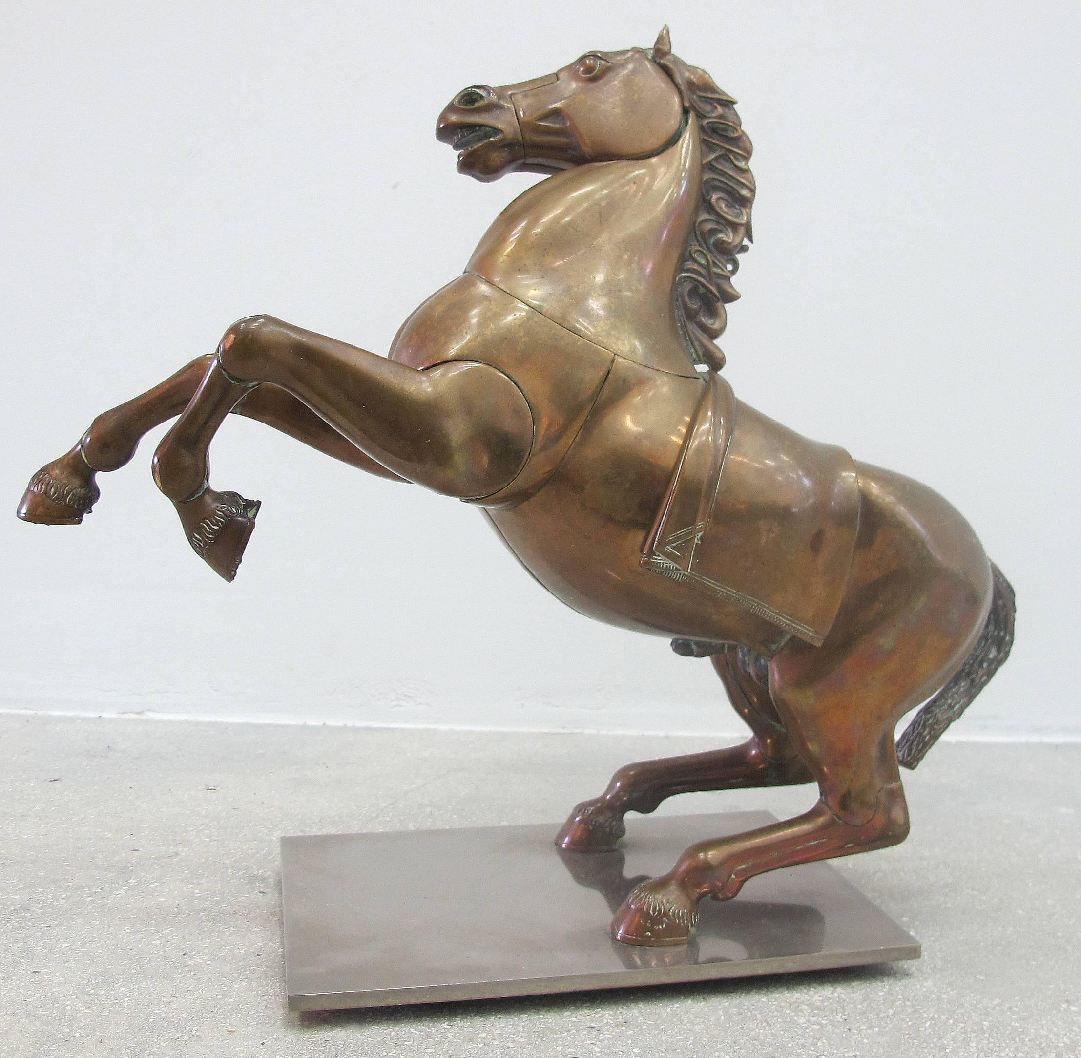 Large bronze horse sculpture by renowned Spanish sculptor Miguel Ortiz Berrocal (1933-2006). Titled "Caballo Casinaide." Horse has a stylized mane which reads Berrocal on one side and Casinaide on the other. Features articulated parts that