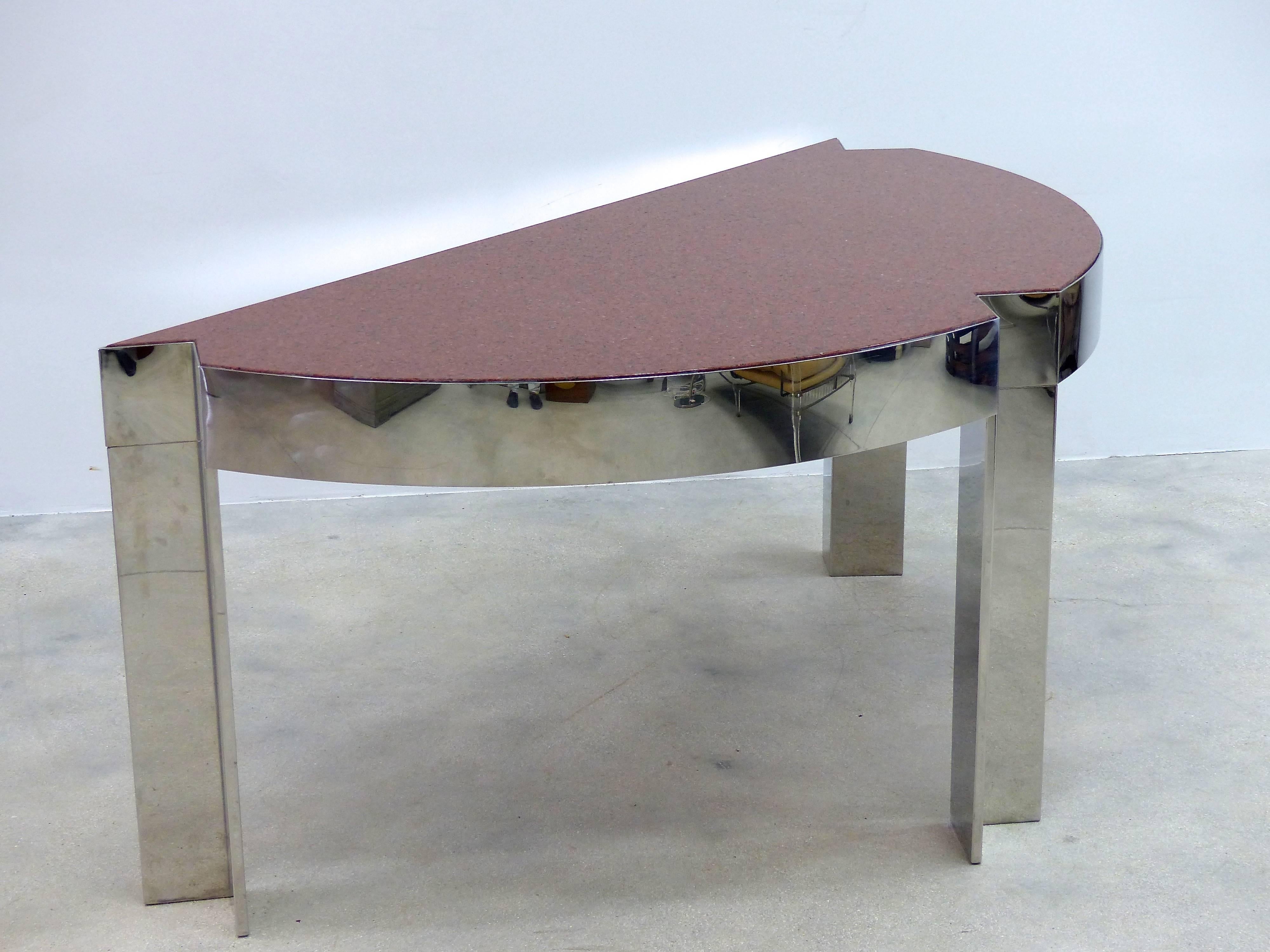 A 1970s highly-polished demilune chrome frame desk with an inset granite top surface designed by Leon Rosen for Pace collection. The three legs are inverted 90 degree angles. Two slender drawers are included on the back.