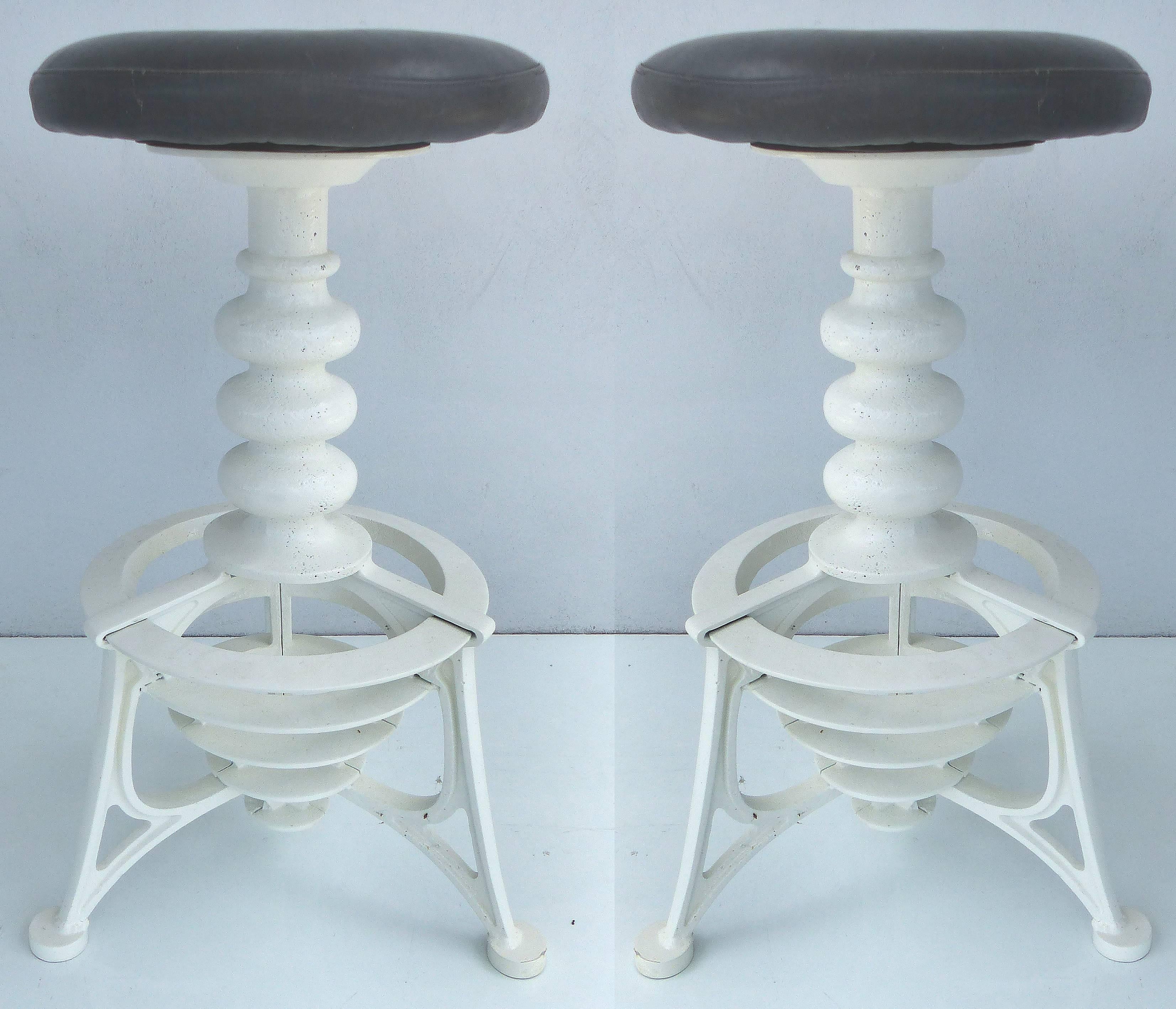20th Century Industrial Cast Iron Interchangeable Stools to Tables

A pair of early 20th century Industrial cast iron stools that have interchangeable tabletops. The original leather swivel seats can be exchanged for custom fitted steel tabletops