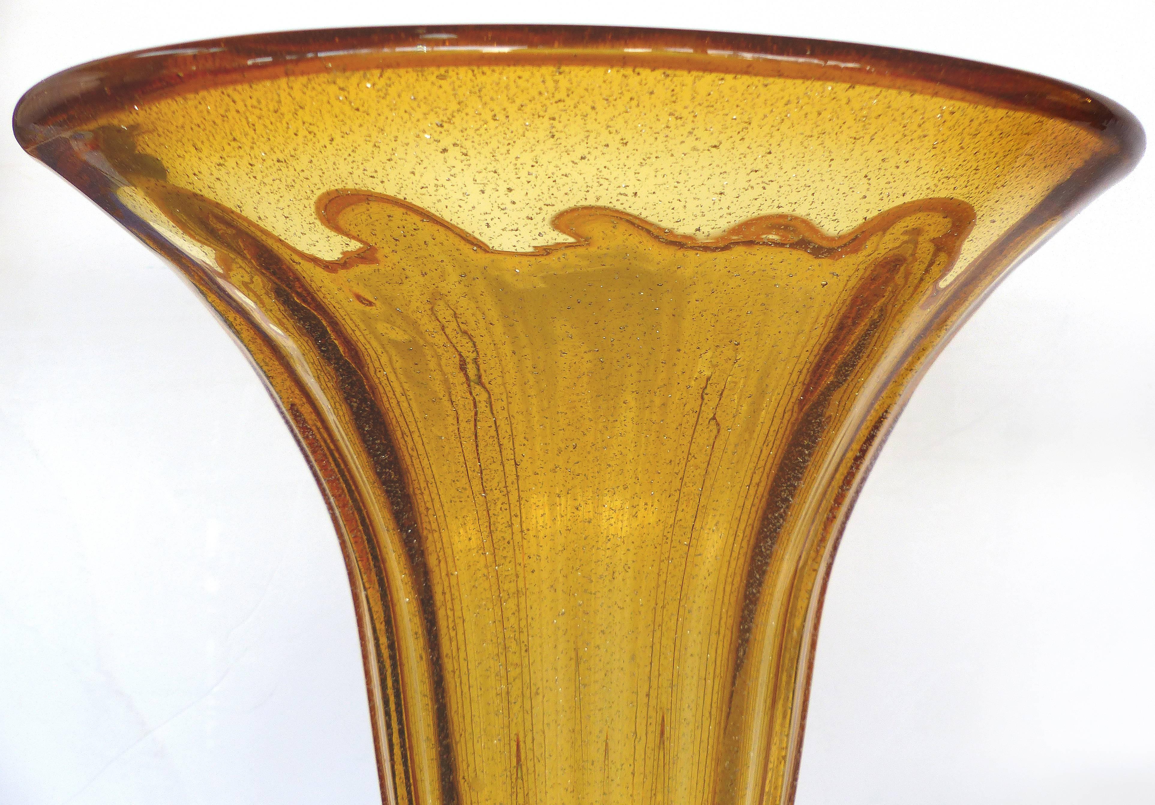 Monumental Pair of Blown Murano Glass Urns with Infused Gold Flakes

A monumental pair of gold infused handblown Murano glass footed urns. Each flared top urn is supported by a decorative gold infused stem and contrasting amber base. Base, 5