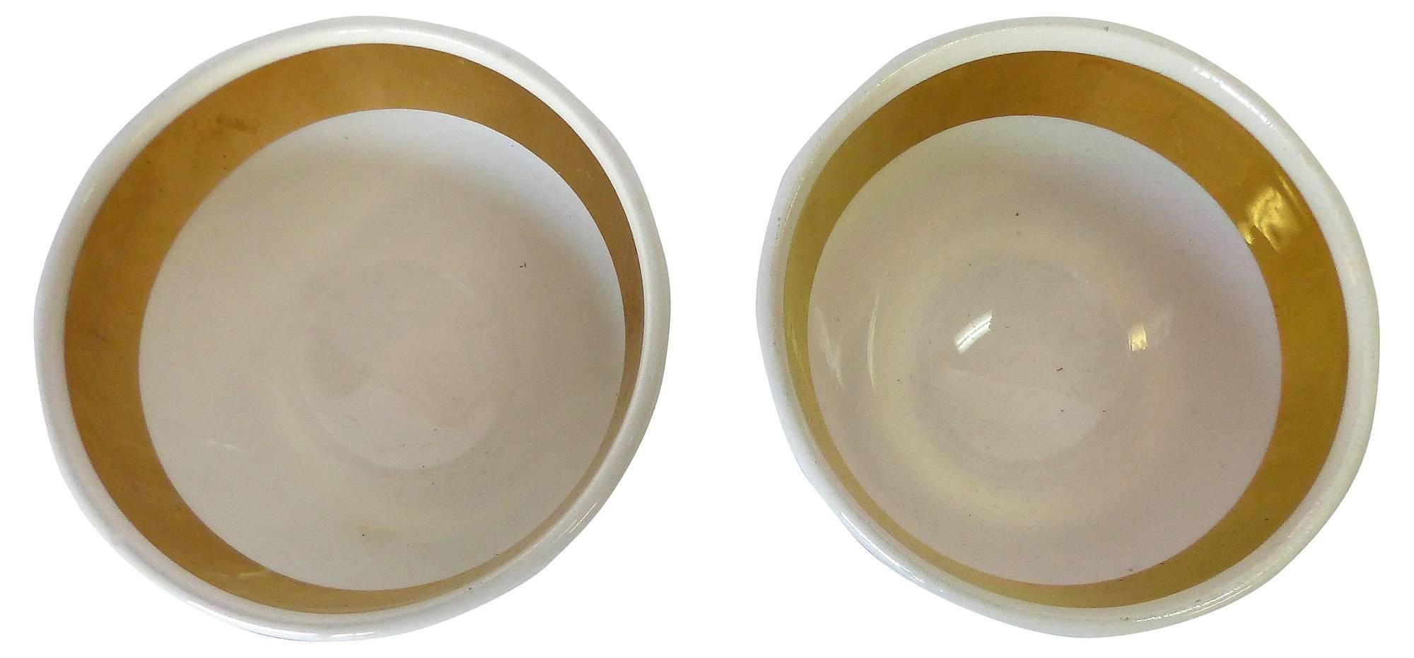 Pair of lithographic design porcelain appetizer bowls with gilt accents and labeled "Almonds" and "Sausages" designed by Piero Fornasetti. Marked Fornasetti on undersides. Rubbed black finish on one bowl. 


  
