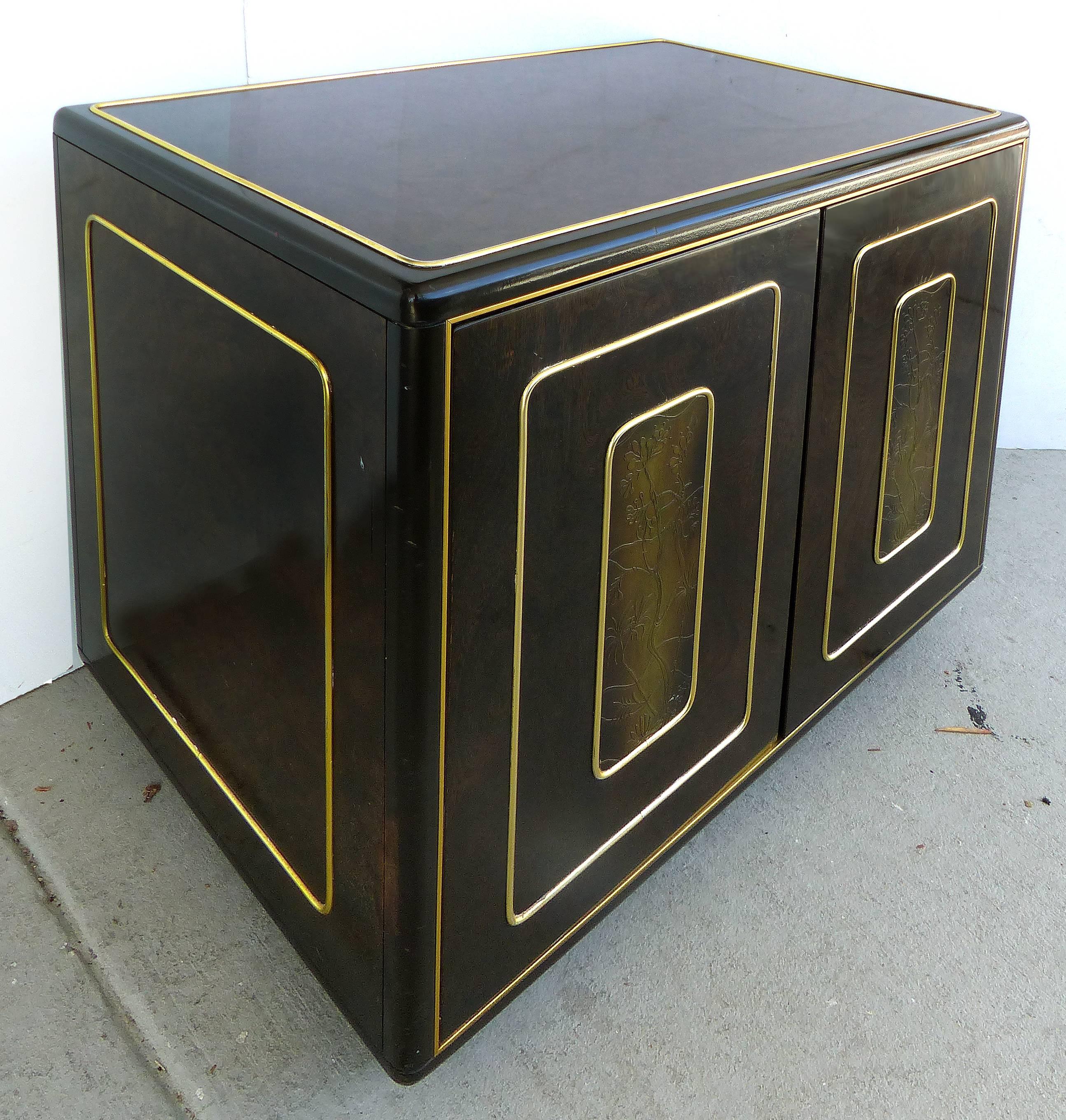 A pair of Mid-Century Modern Romweber burl wood nightstands with inset etched brass panels and brass trim. The etched panels have an Asian inspired floral motif. Each has a pair of touch-latch doors which open to reveal ample storage with removable