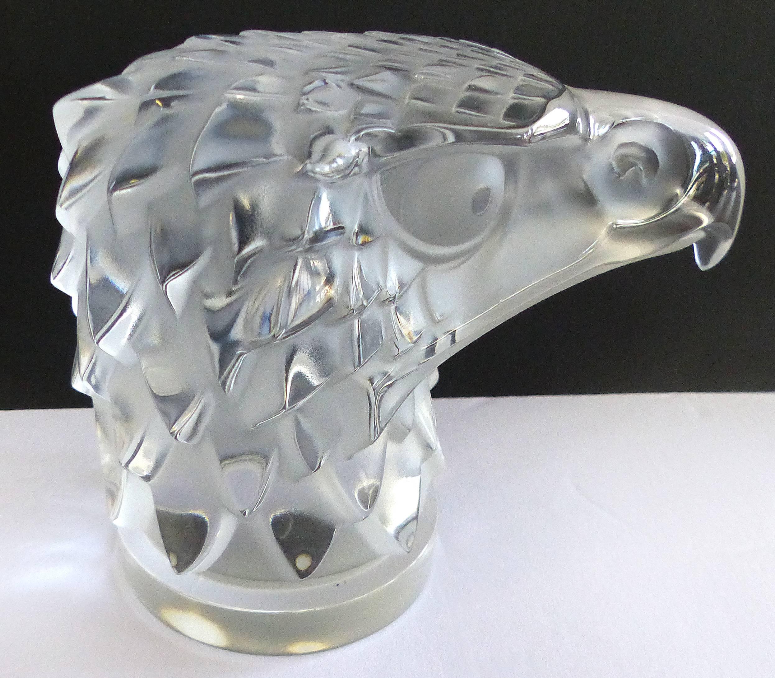 A mid-20th century carved crystal Lalique Tete d'aigle eagle head paperweight that was originally designed as a car hood ornament in the 1920s brass car era. Signed by hand Lalique, a circle with two in the center and France on base.
  