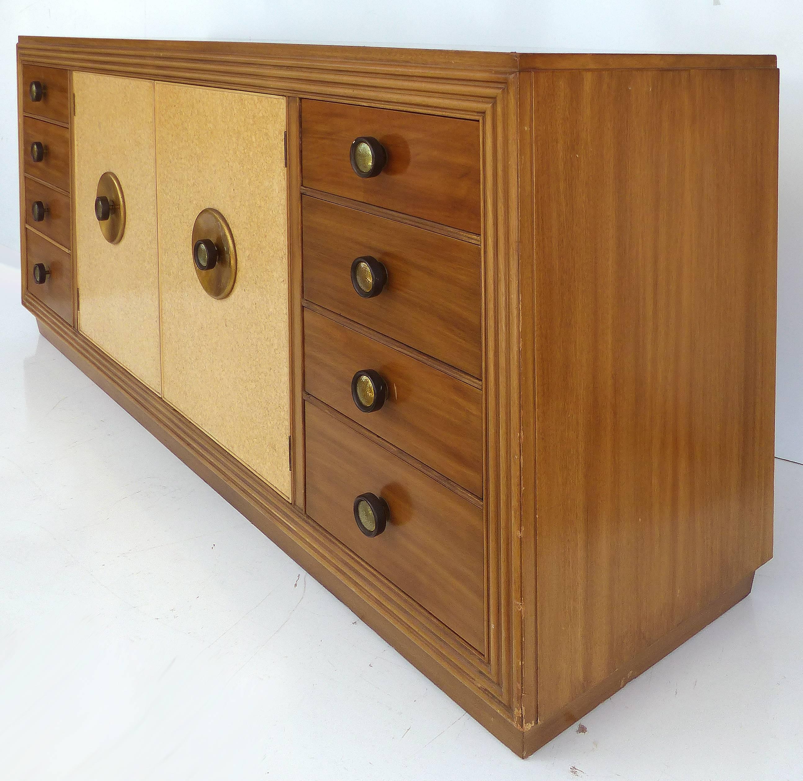 Paul Frankl for Johnson Furniture Mahogany, Cork and Hammered Brass Sideboard

An original Paul Frankl sideboard, circa 1940 with solid mahogany construction. The front centre doors are covered in cork and open to reveal fitted drawers. These doors